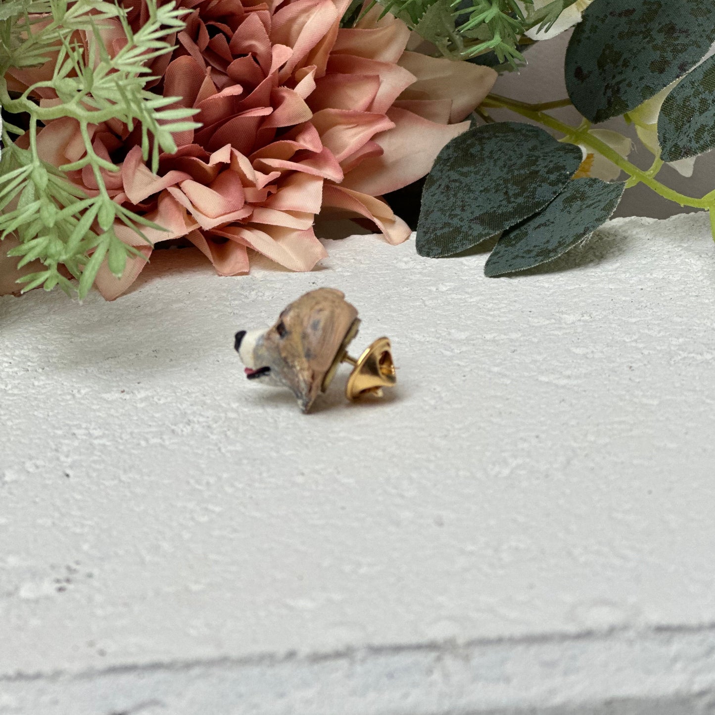Custom dog lapel pin on white background with flowers.