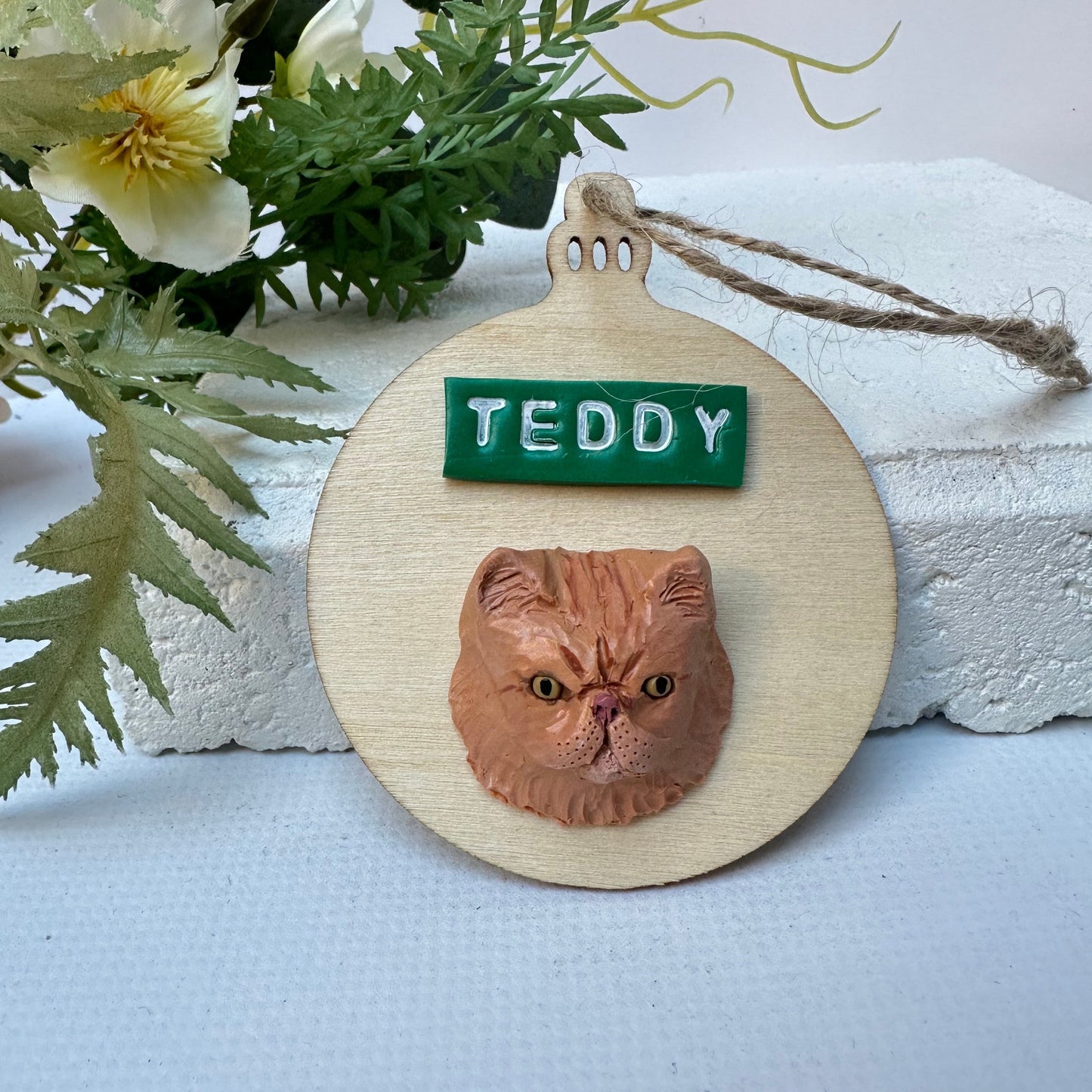 Bauble shaped timber Christmas ornament with polymer clay handmade cat face and name.