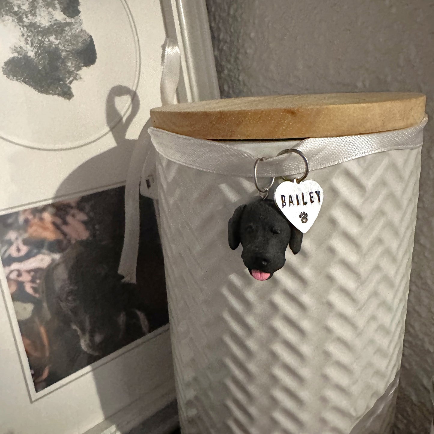 Custom dog urn charm hanging on urn with pet's ashes.
