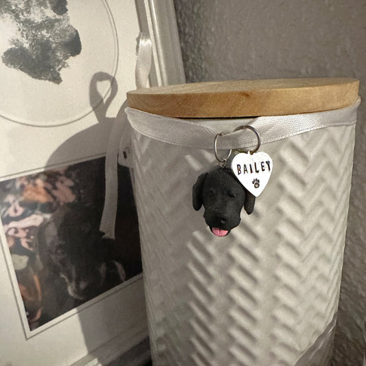 Custom dog urn charm hanging on urn with pet's ashes.