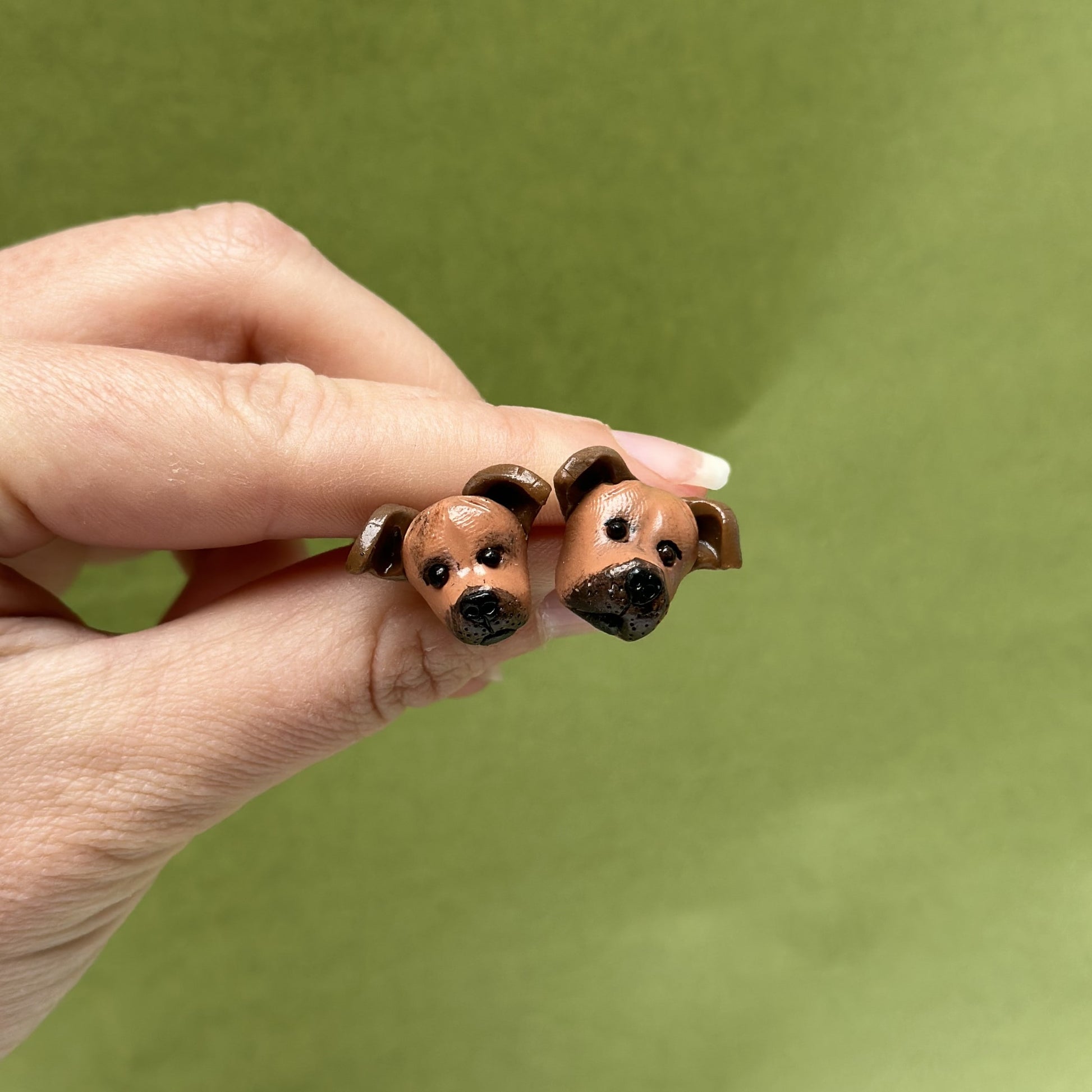 Handmade staffie stud earrings by Pawfect Love, positioned in front of green background
