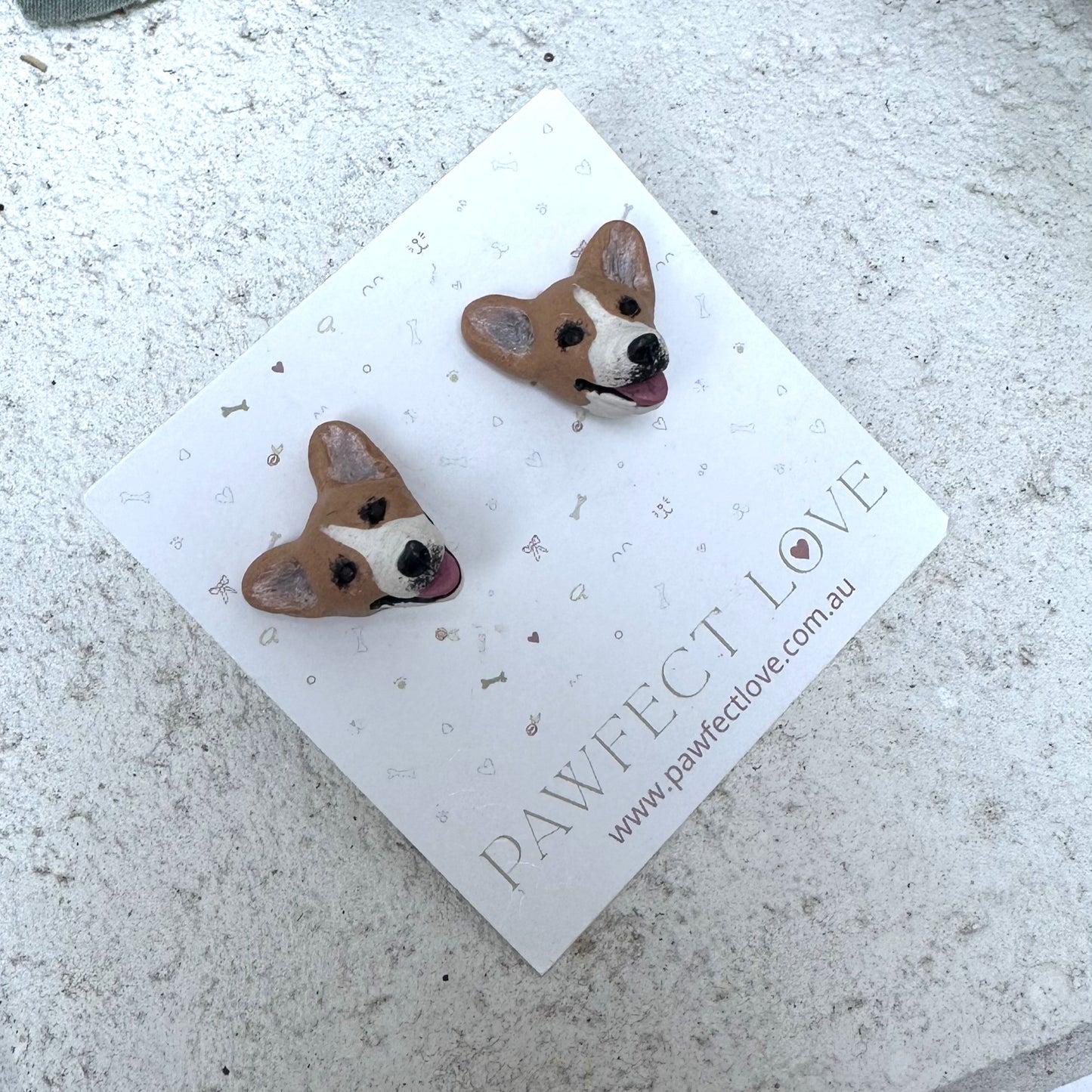 Corgi Dog-shaped earrings on a 'PAWFECT LOVE' branded card on a textured surface