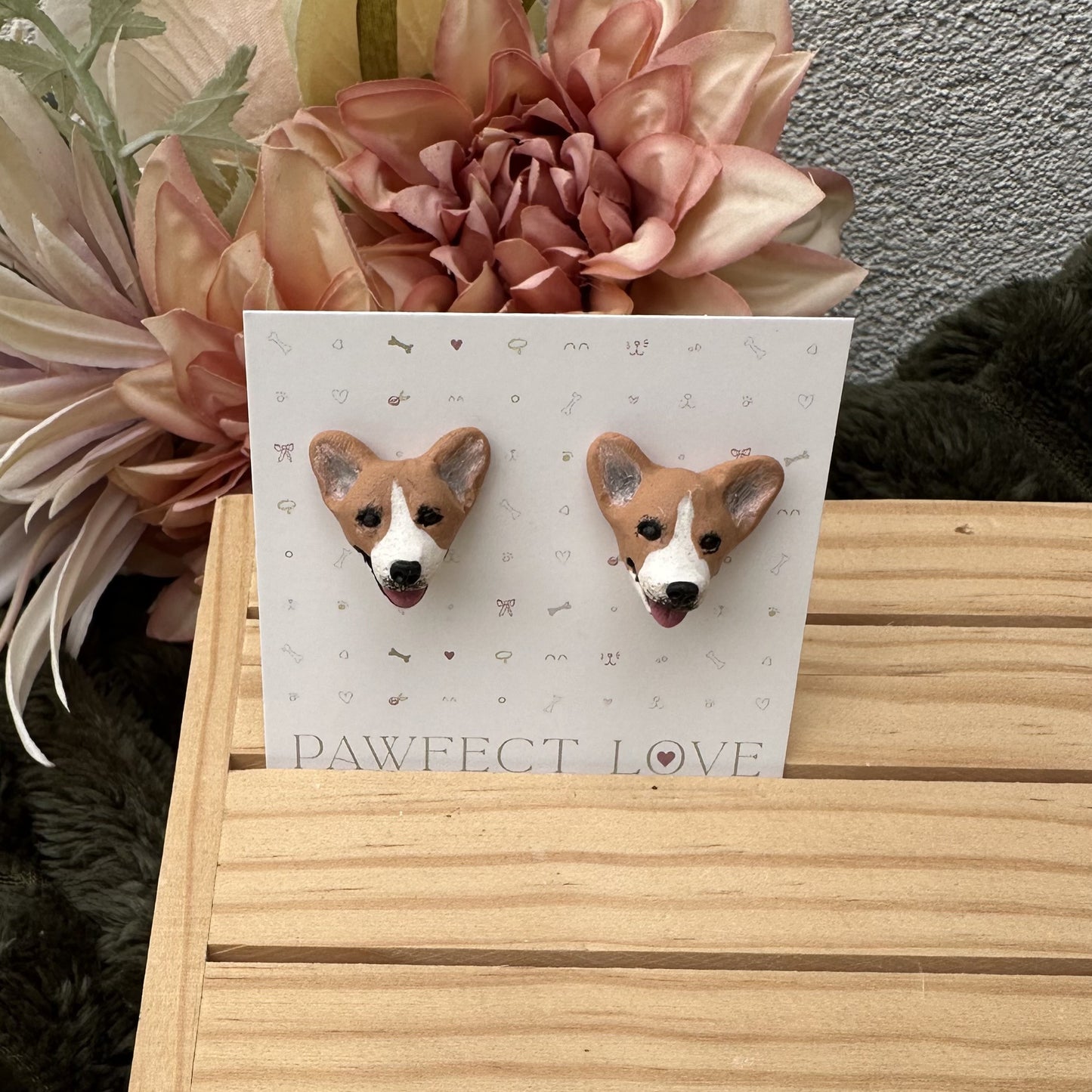 Corgi dog-shaped earrings on a 'PAWfect Love' card with flowers in the background