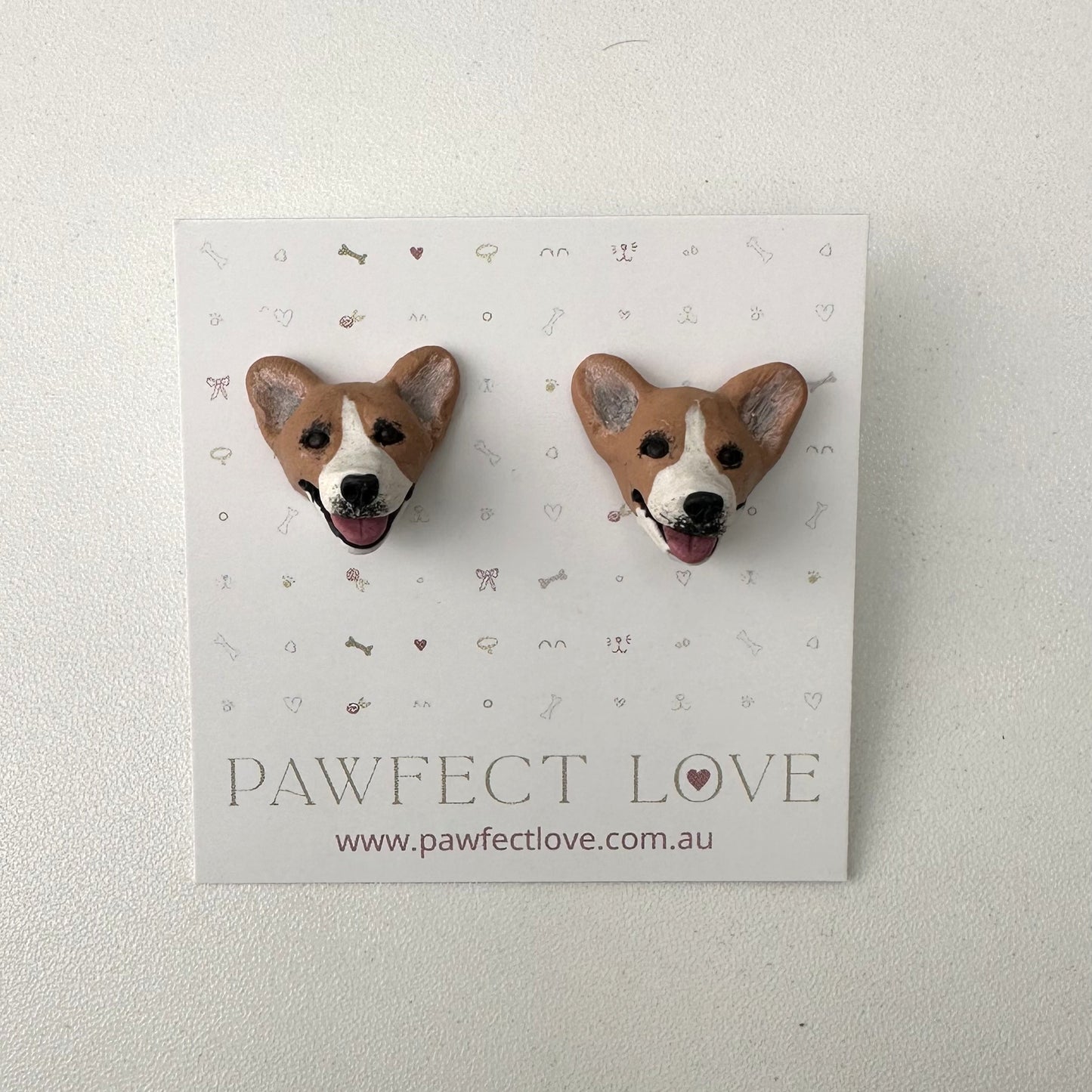 Pair of corgi dog-shaped earrings on a 'Pawfect Love' branded card.