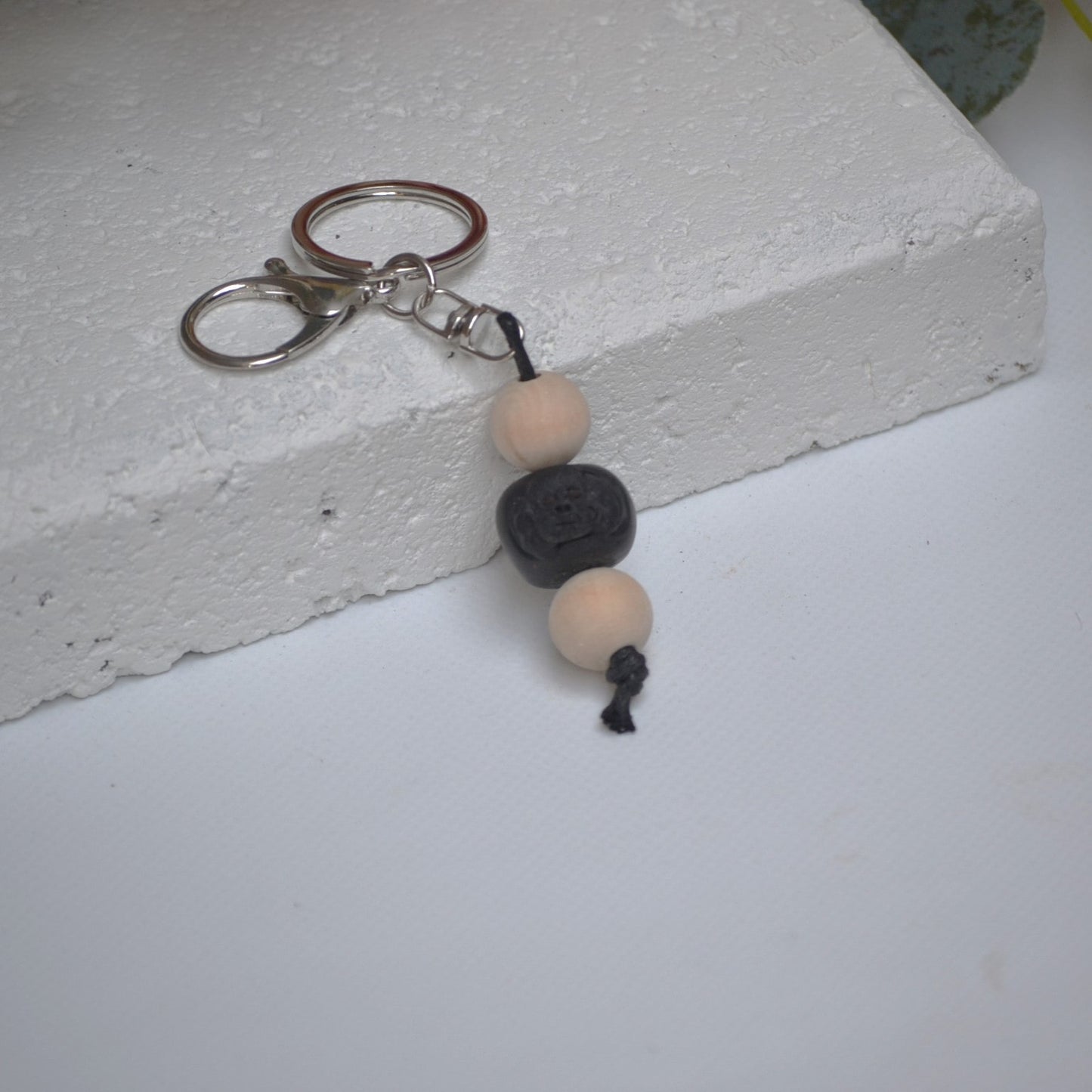 Handmade black poodle dog polymer clay and timber keying on white textured background