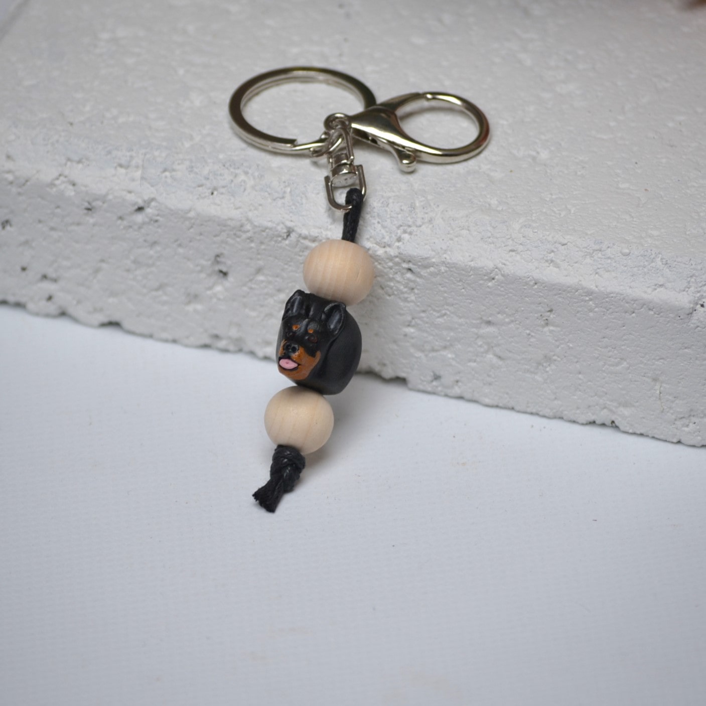 Handmade Kelpie dog polymer clay and timber keying on white textured background