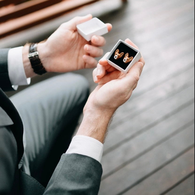 Groom opening custom pet cufflinks in a gift box.