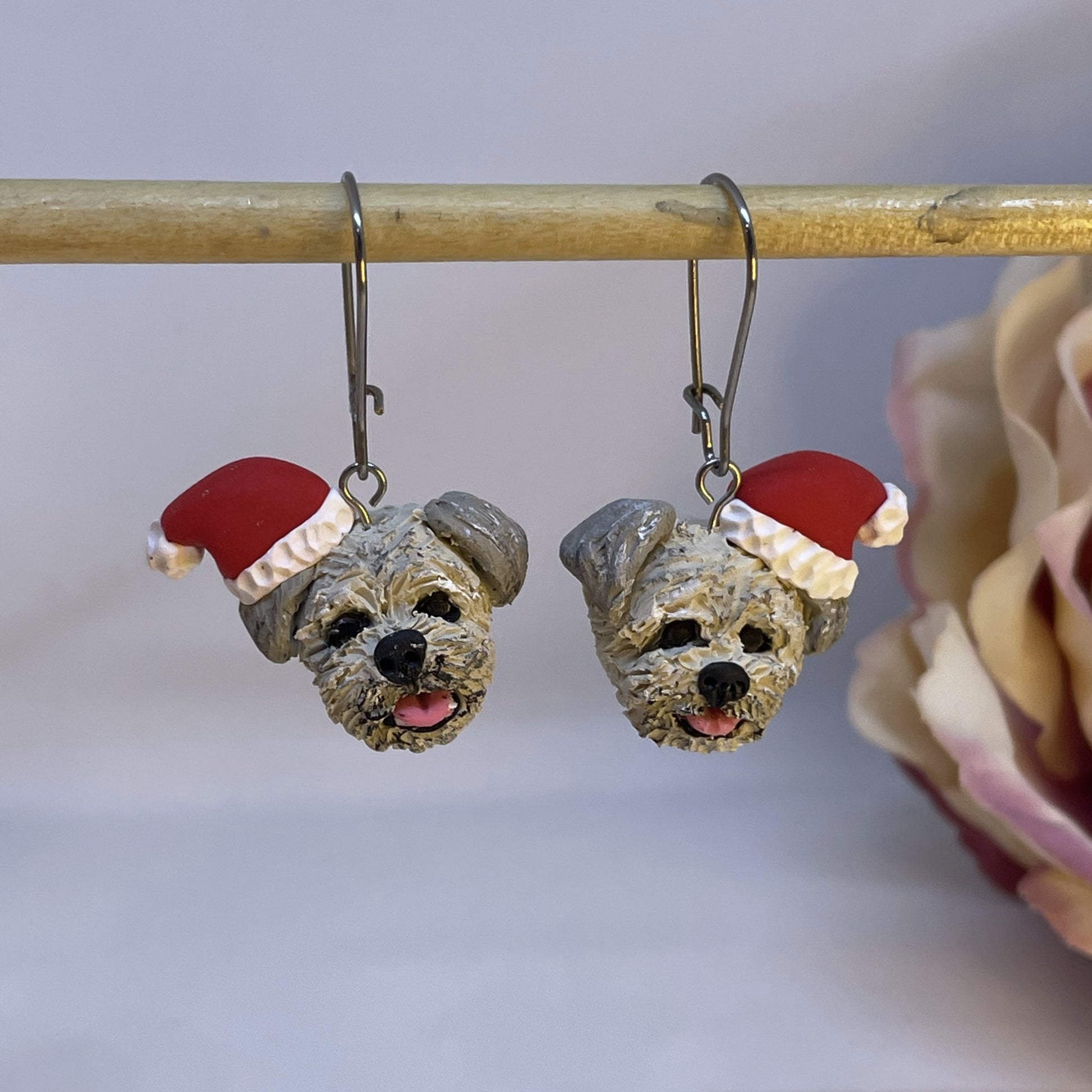 Handmade custom dog dangle earrings wearing santa hats.