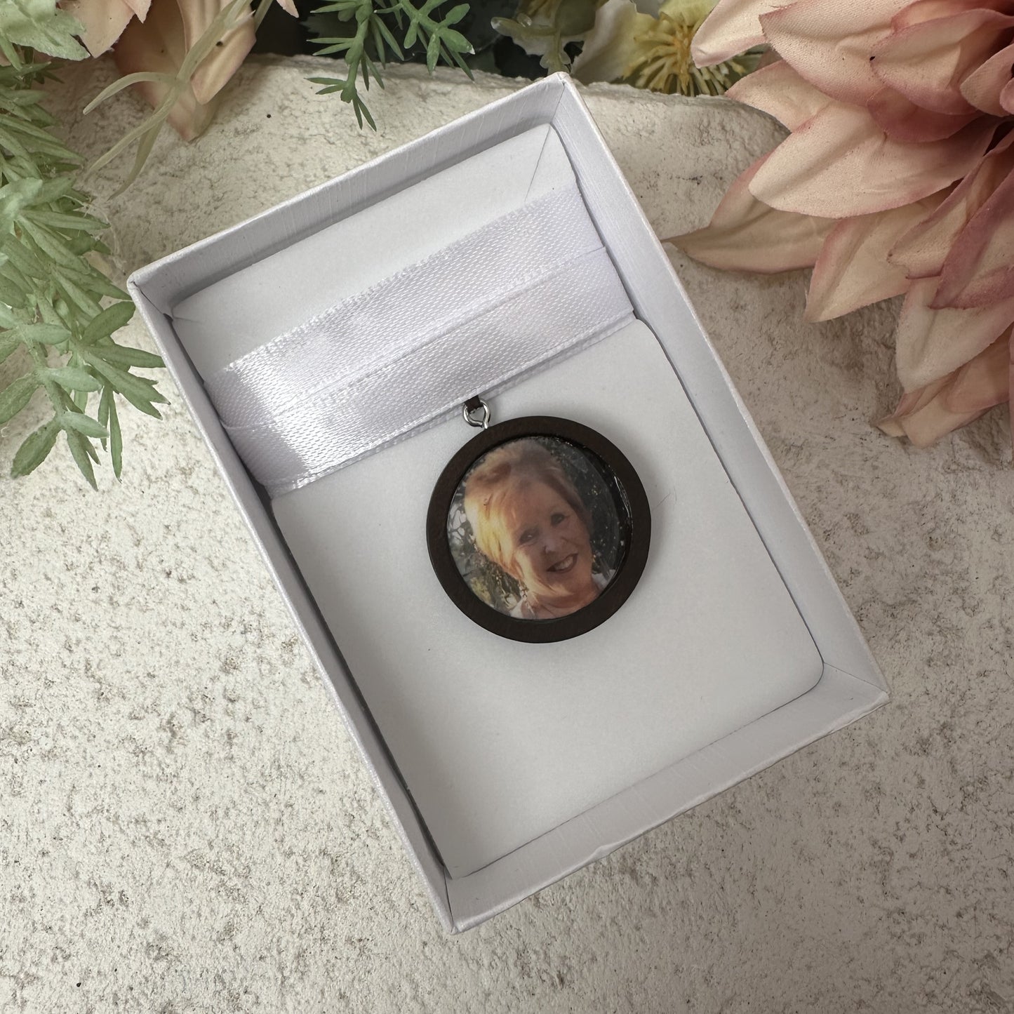 Memorial photo charm of grandmother for bridal bouquet, pictured in white giftbox.