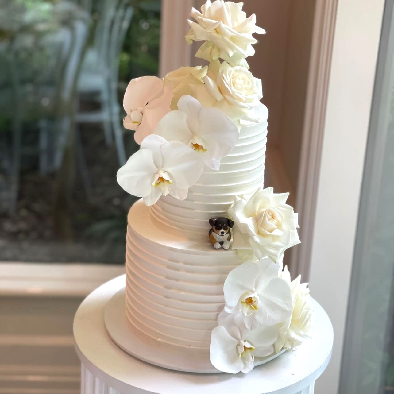 Custom dog peeking topper in a real wedding cake.