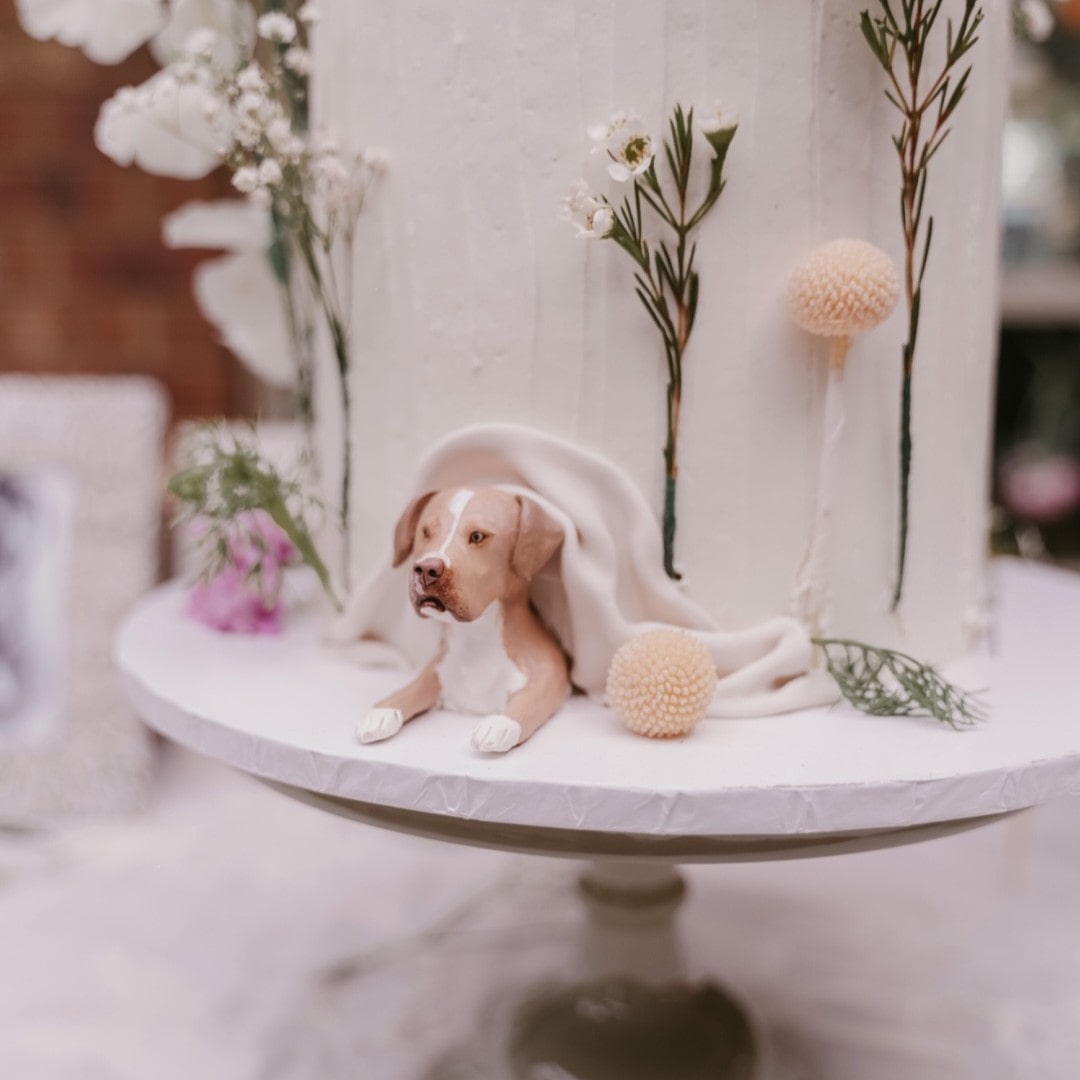 Custom pet dog peeking topper in a real wedding cake.