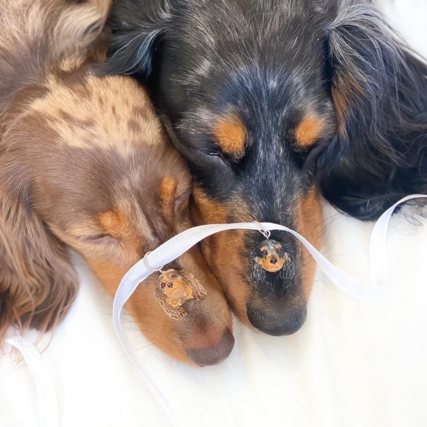 Handmade bouquet dog pendants of 2 dachshunds resting on the snout of their models