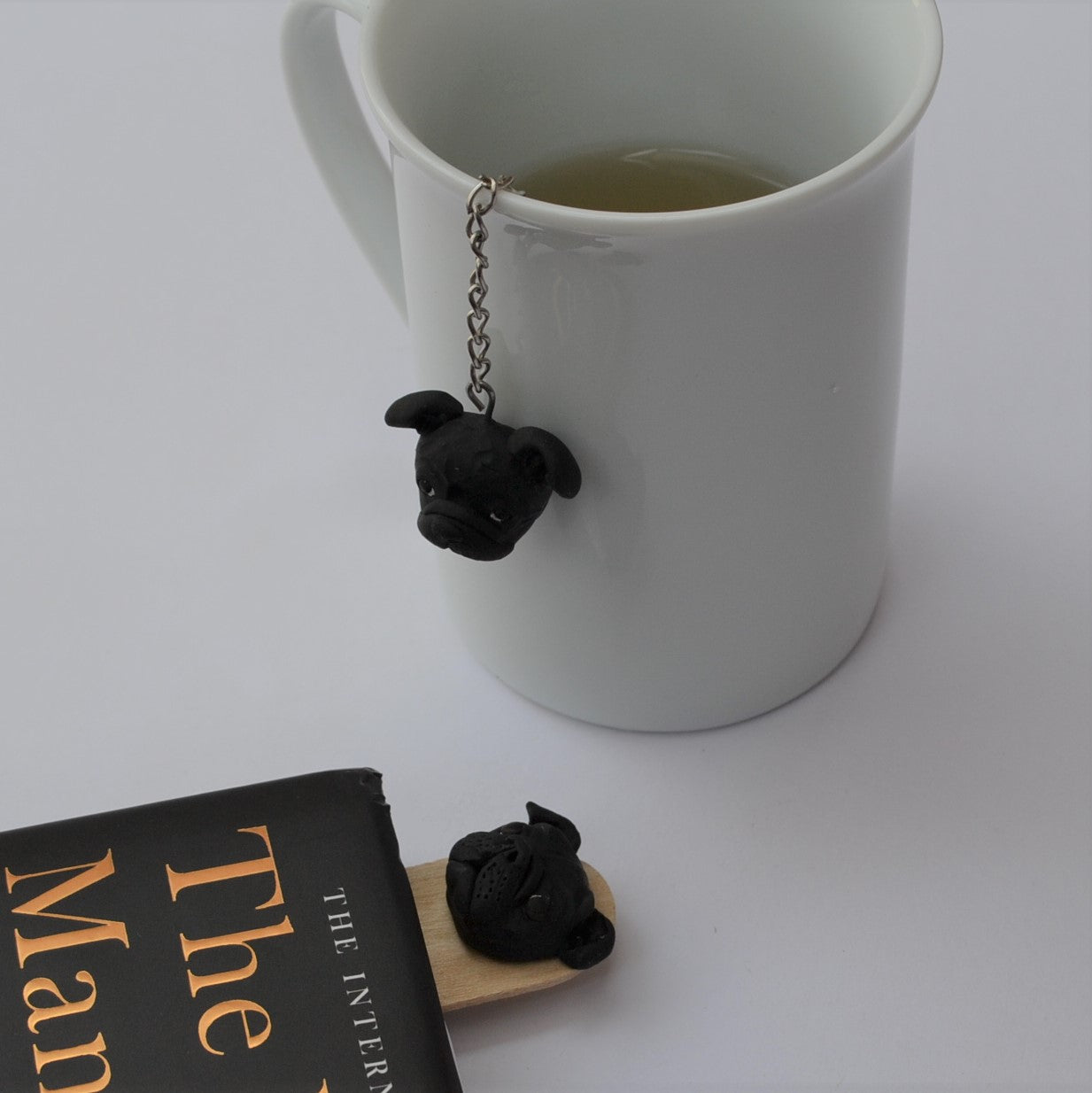 Custom dog handmade mesh ball tea strainer in use on a white mug with a matching handmade dog bookmark