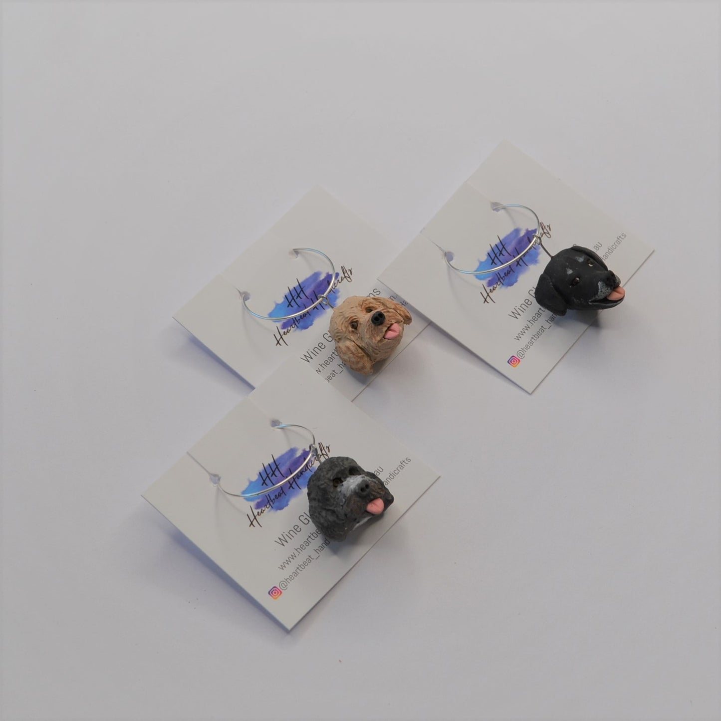 3 handmade wine glass charms of dogs on display cards