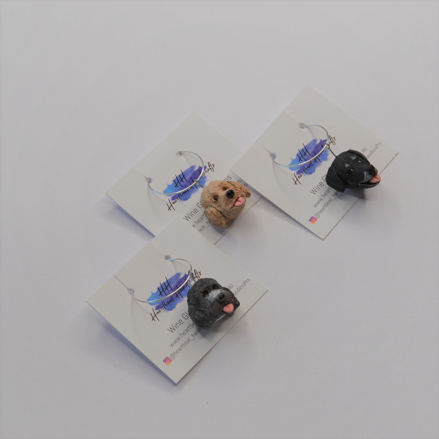 3 handmade wine glass charms of dogs on display cards