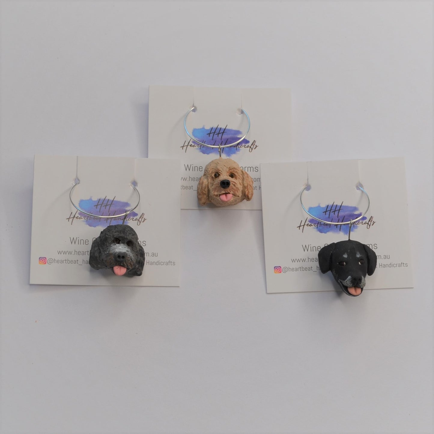 3 handmade wine glass charms of dogs on display cards