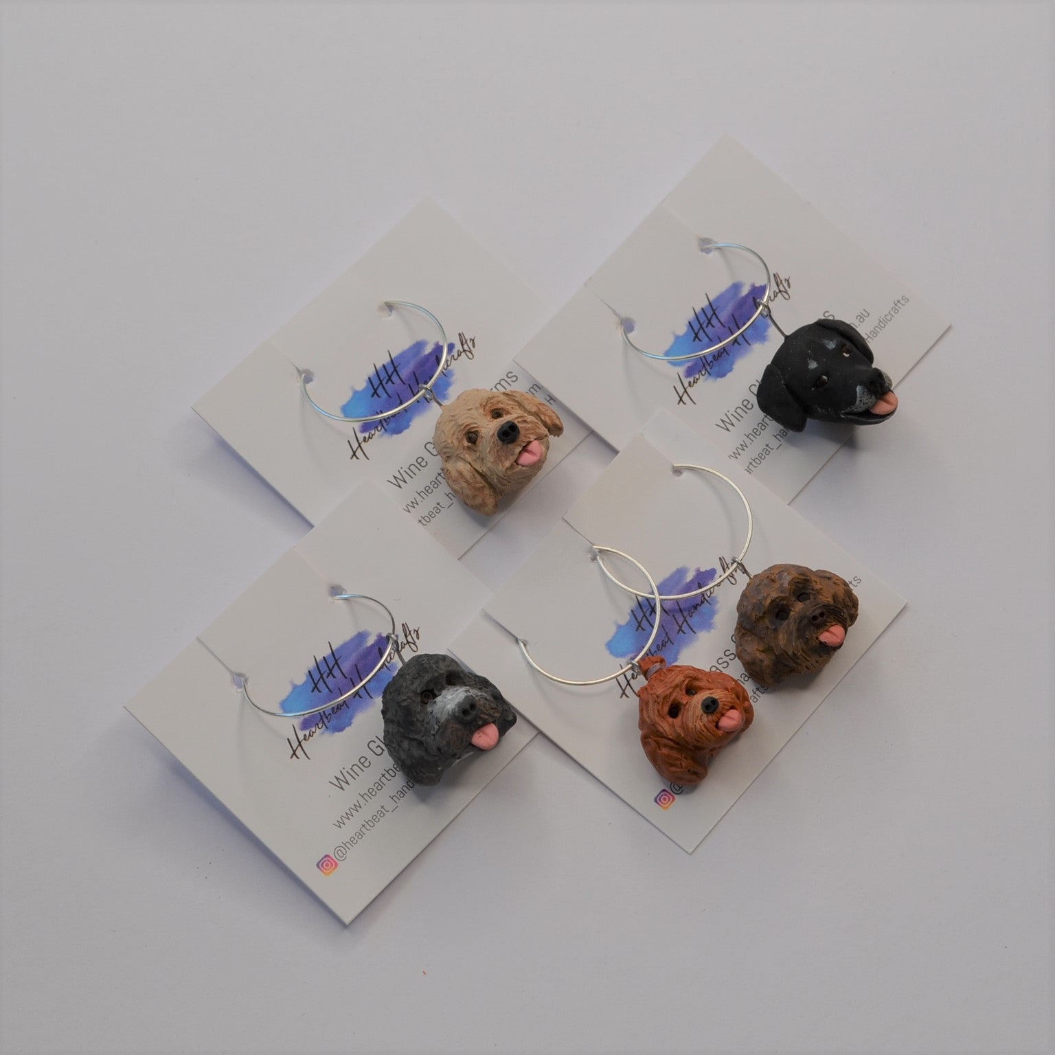 5 handmade wine glass charms of dogs on display cards