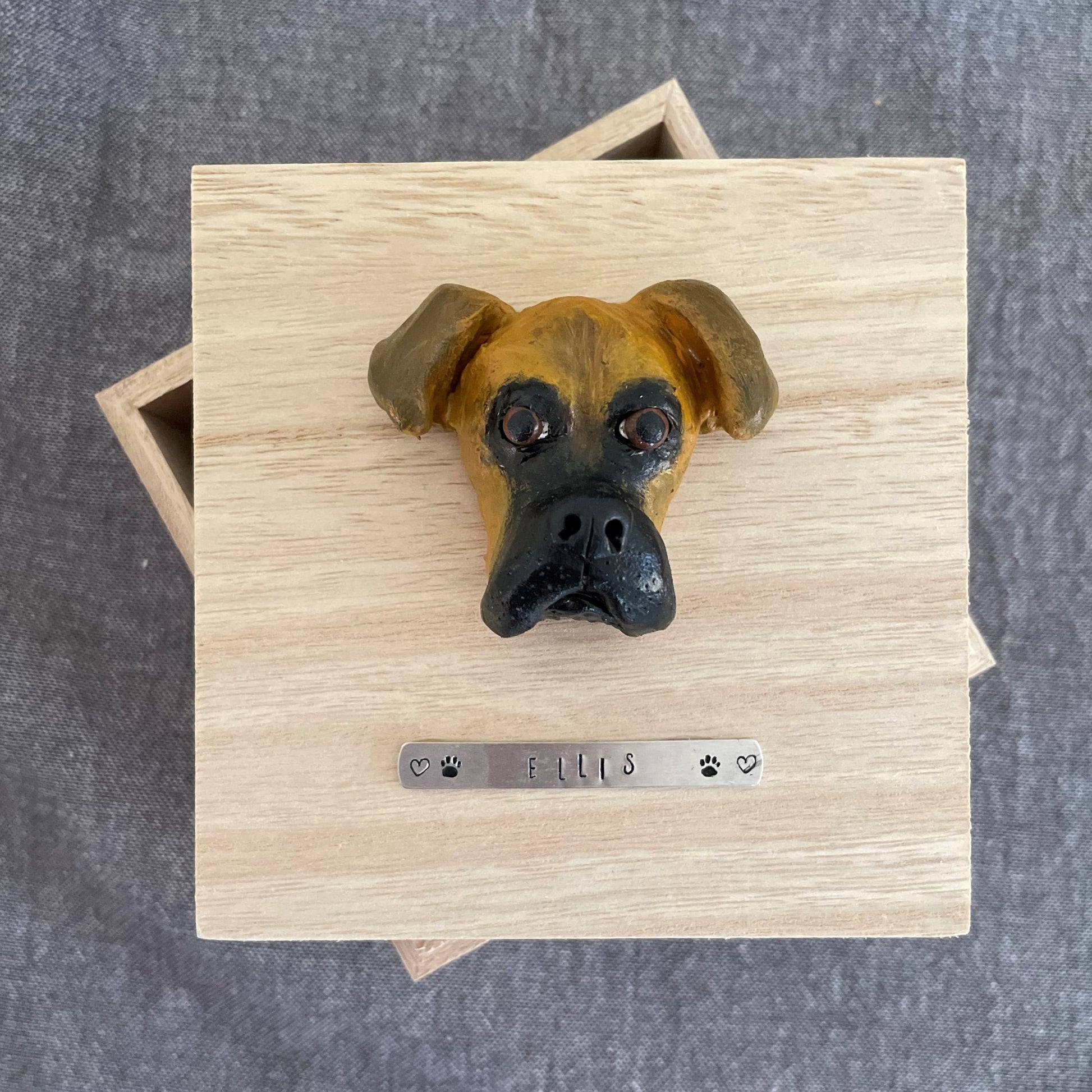 Custom timber pet memorial keepsake box with handscultped dog face on the lid, with a name plaque reading Ellis.