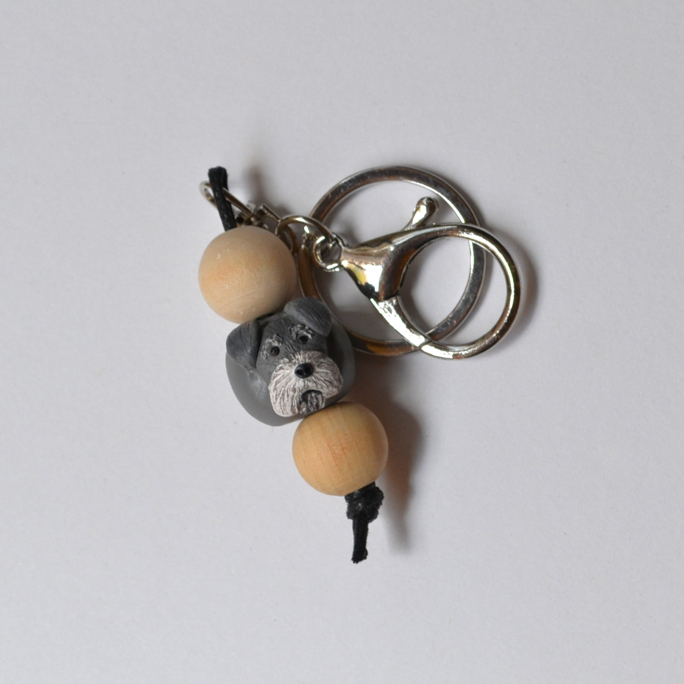 Handmade timber and polymer clay grey schnauzer dog keychain on white background
