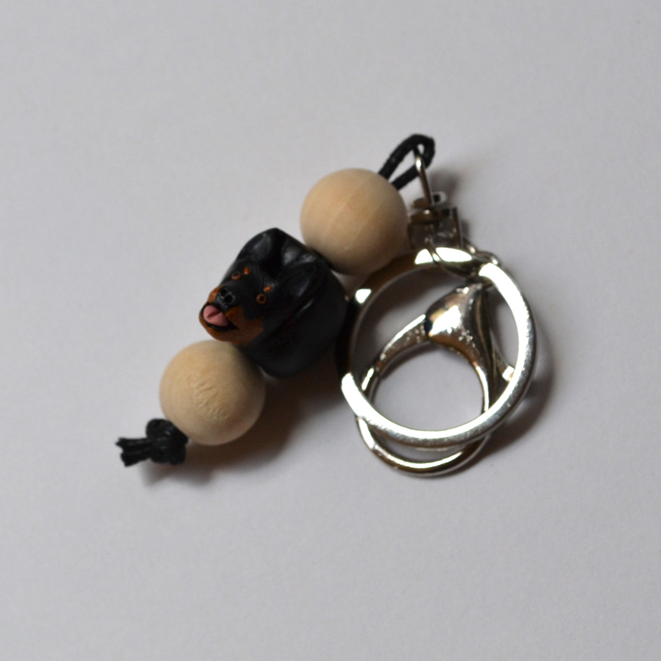Polymer clay and timber handmade kelpie keyring on white background angled