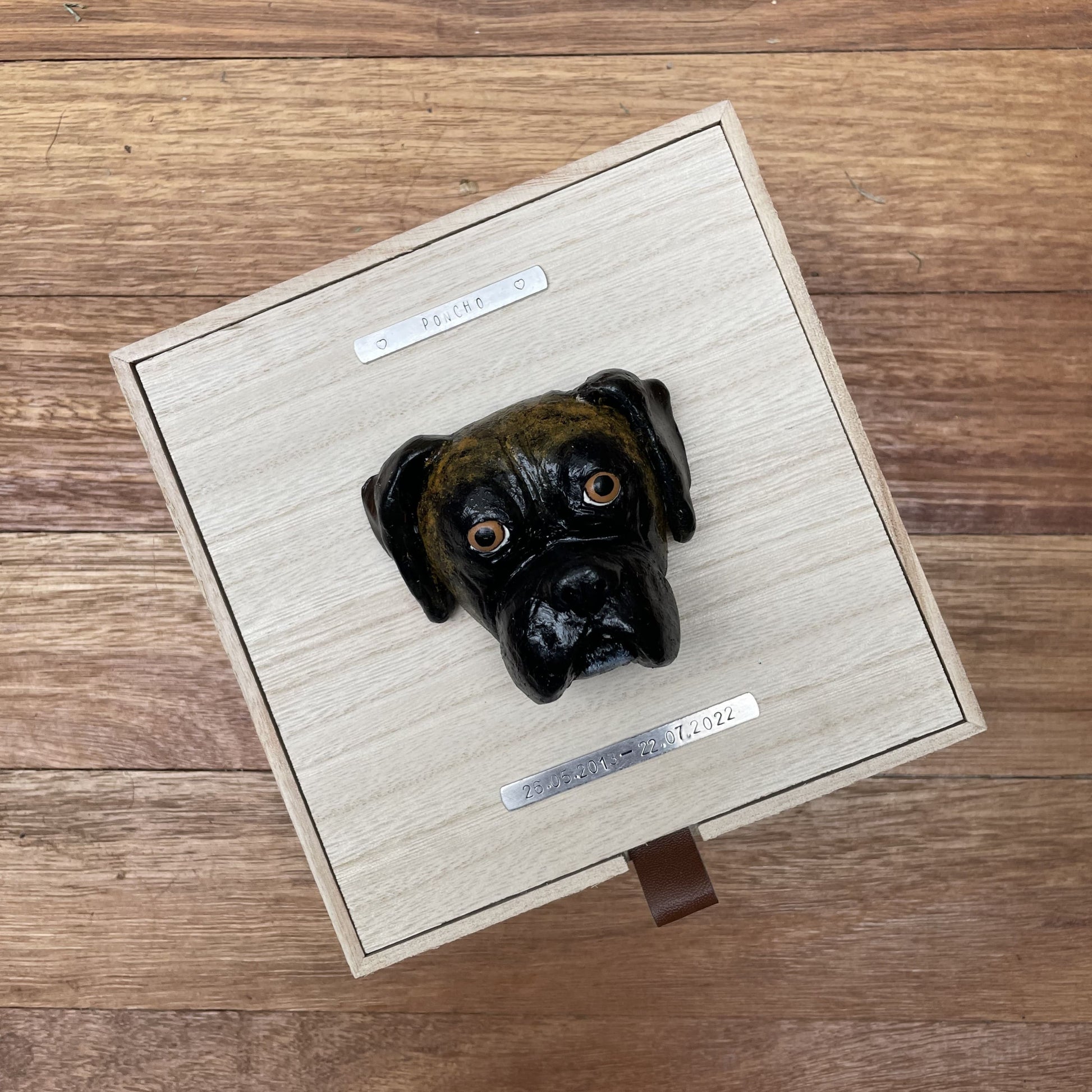 Custom timber pet memorial keepsake box with handscultped dog face on the lid, with a name plaque reading Poncho.