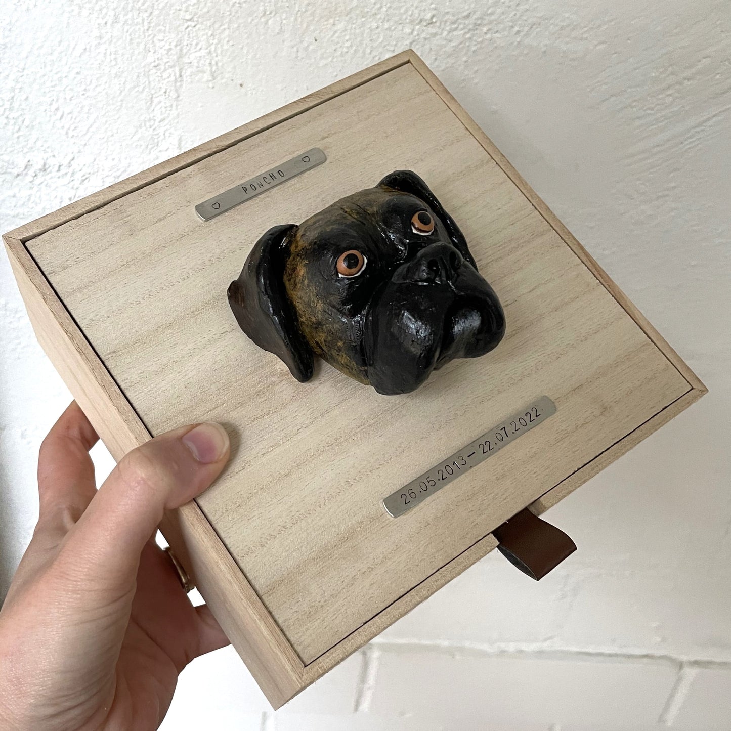 Custom timber pet memorial keepsake box with handscultped dog face on the lid, with a name plaque reading Poncho.