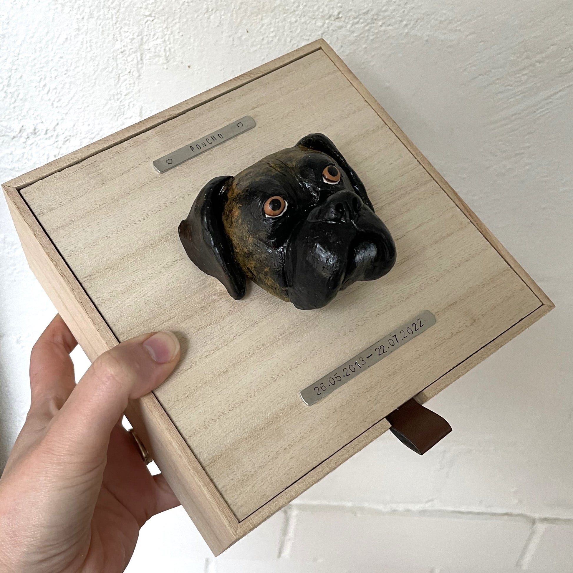 Custom timber pet memorial keepsake box with handscultped dog face on the lid, with a name plaque reading Poncho.