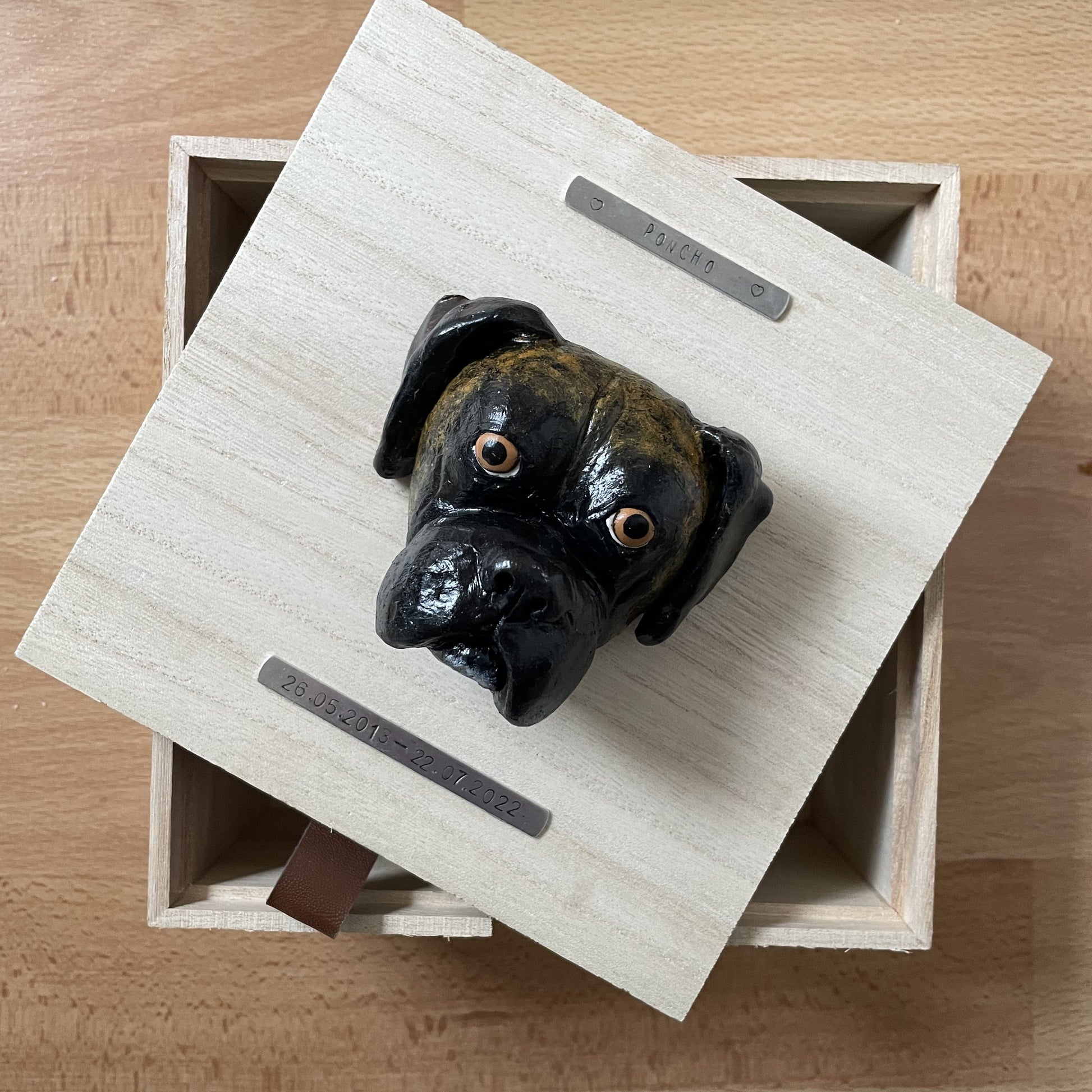 Custom timber pet memorial keepsake box with handscultped dog face on the lid, with a name plaque reading Poncho.