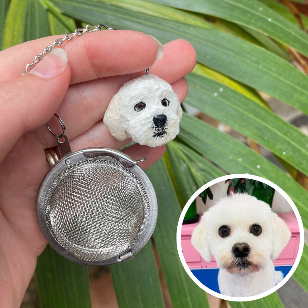 Handmade custom pet face mesh ball tea strainer being held.