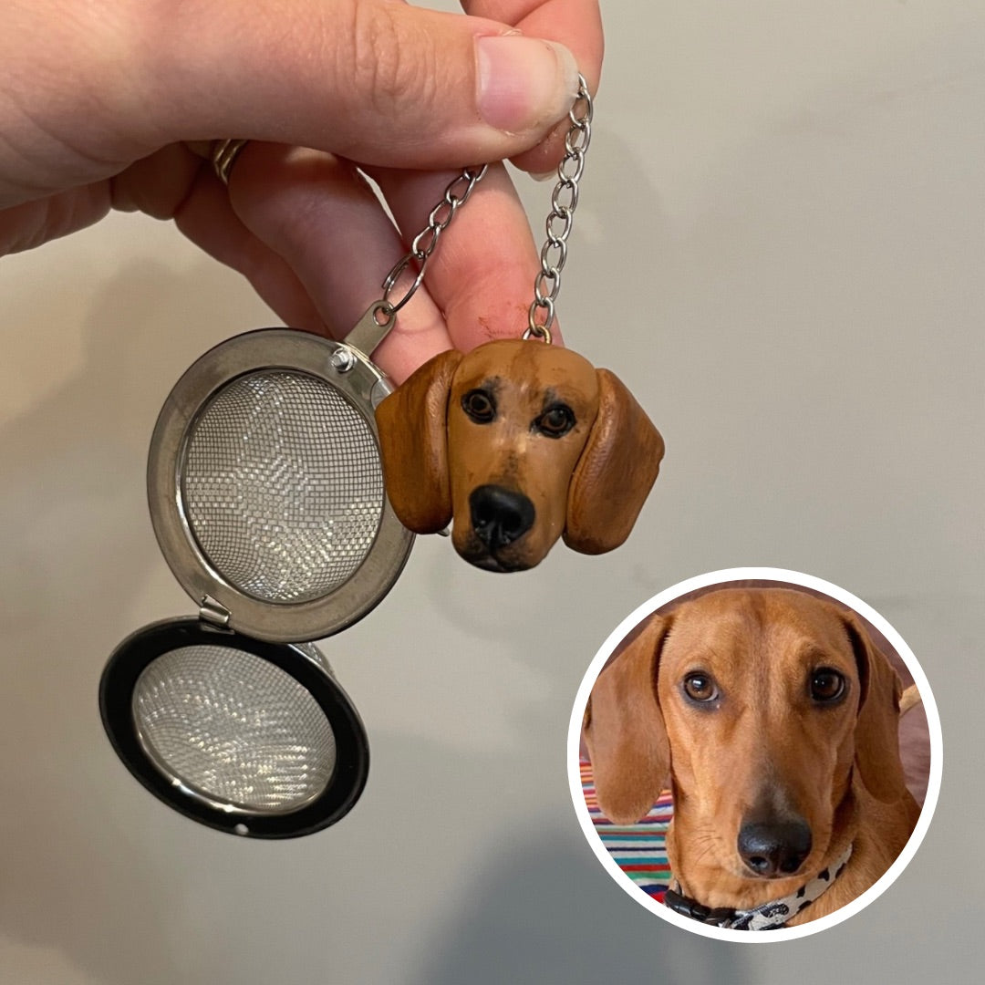 Handmade custom pet face mesh ball tea strainer being held.