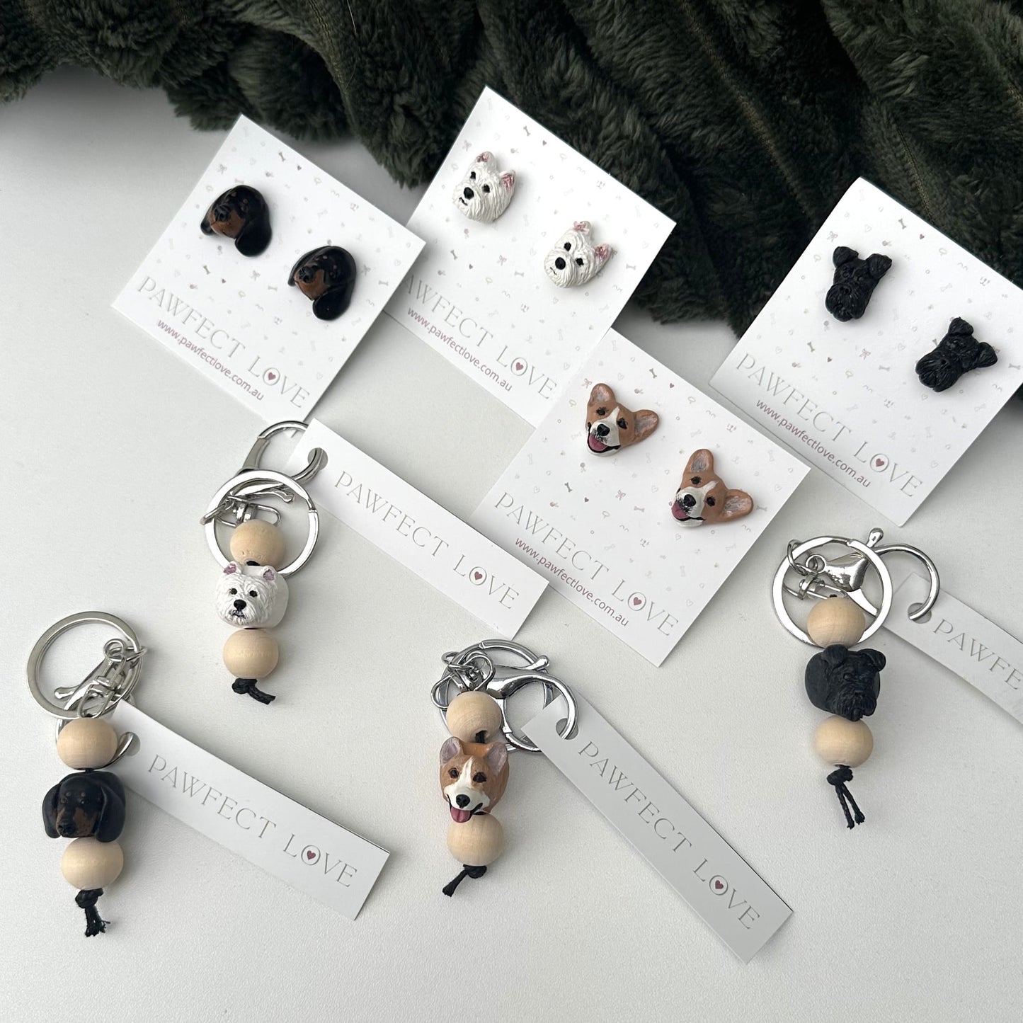 Dog-themed keychains and earrings on display with branded cards.