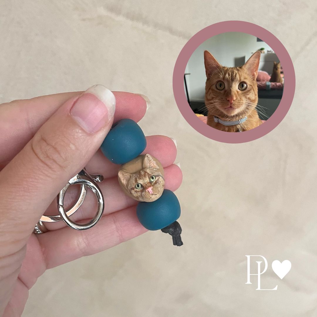 Handmade custom pet keyring with a ginger cat face between plain turquoise beads.