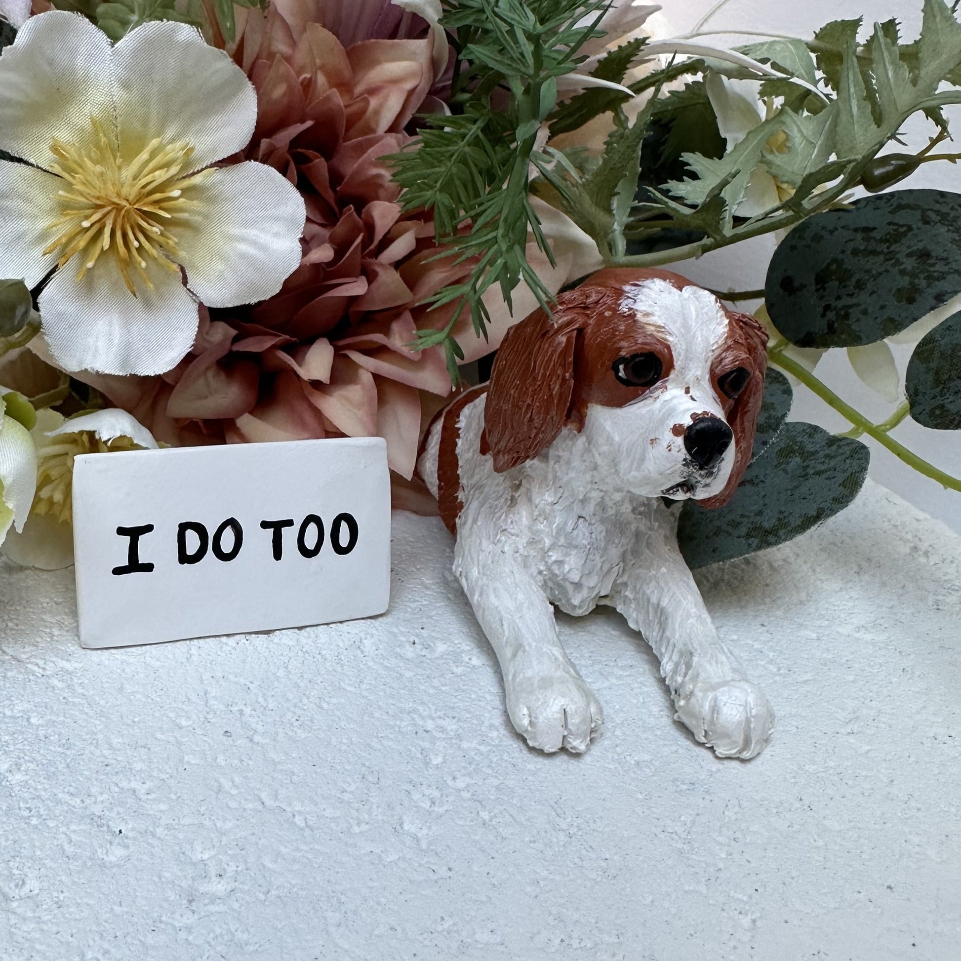 Cavalier king charles spaniel peeking wedding cake topper beside a sign that reads I Do Too,