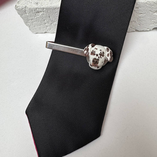 Black tie with a Dalmatian custom handmade tie clip on a light gray surface