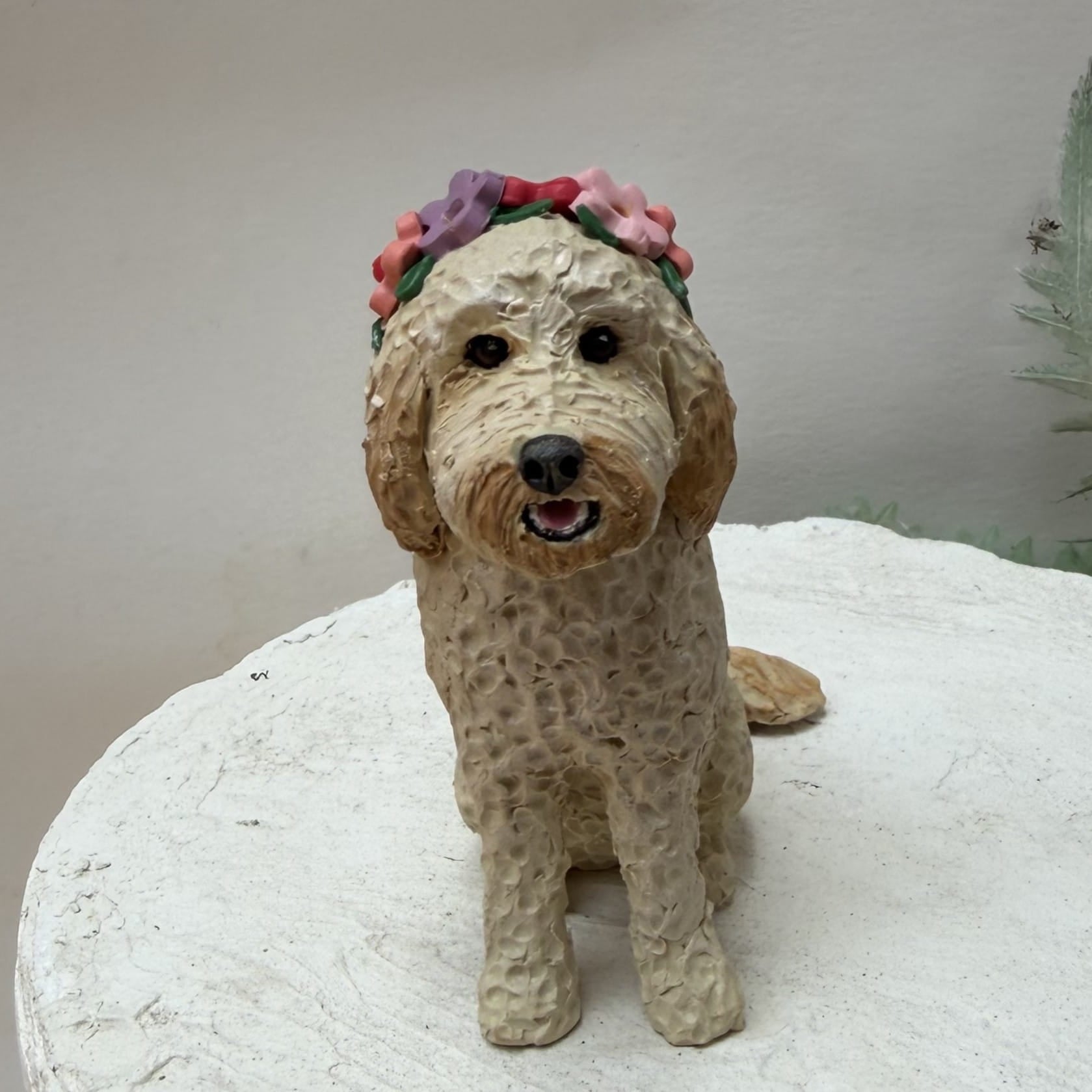 Dog figurine with a floral headband on a white surface