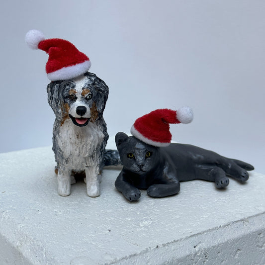 Handmade custom Aussie Shepherd dog and laying grey cat figurines wearing santa hats