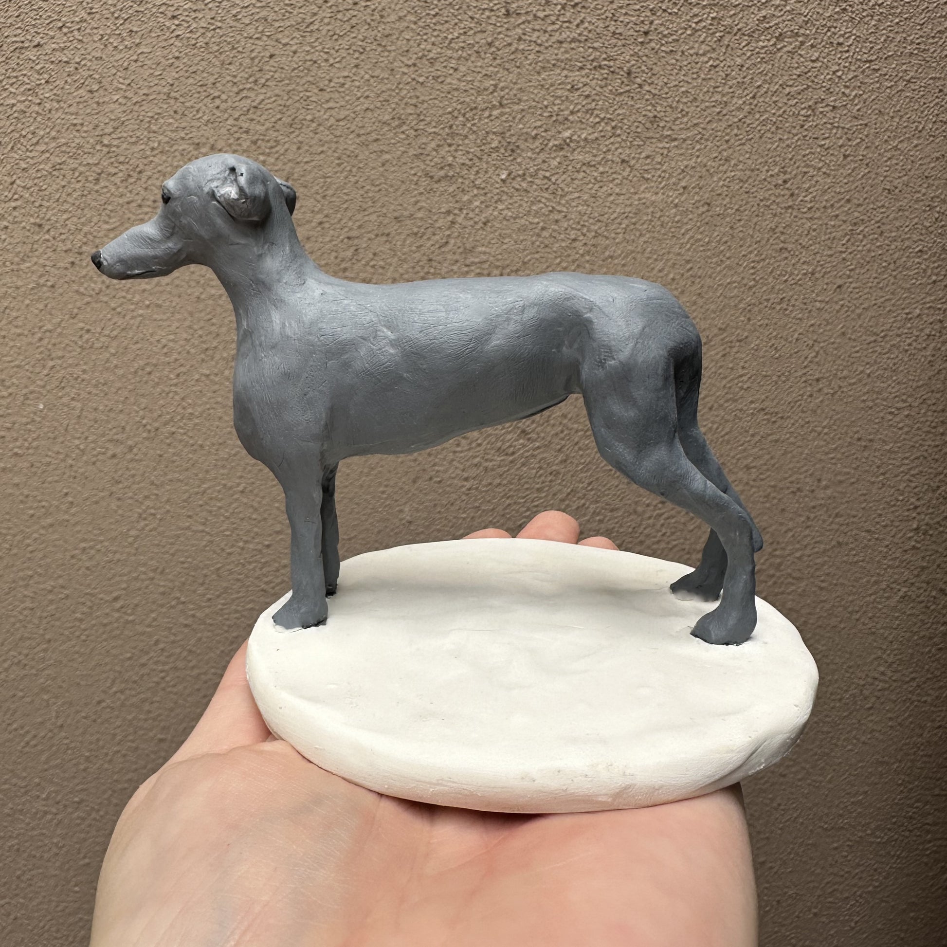 Handmade custom greyhound wedding cake topper on white base.