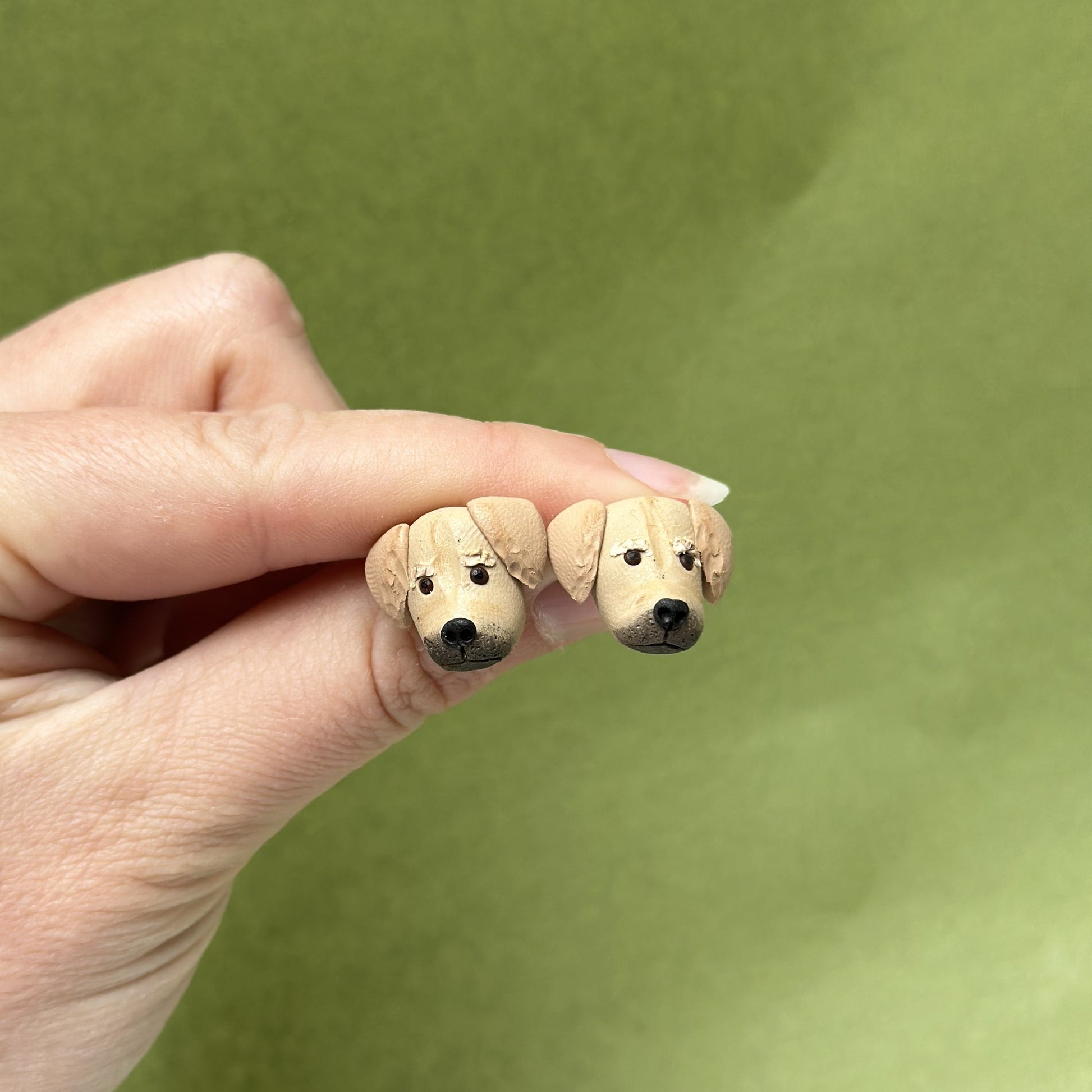 Handmade golden retriever stud earrings by Pawfect Love, positioned in front of green background