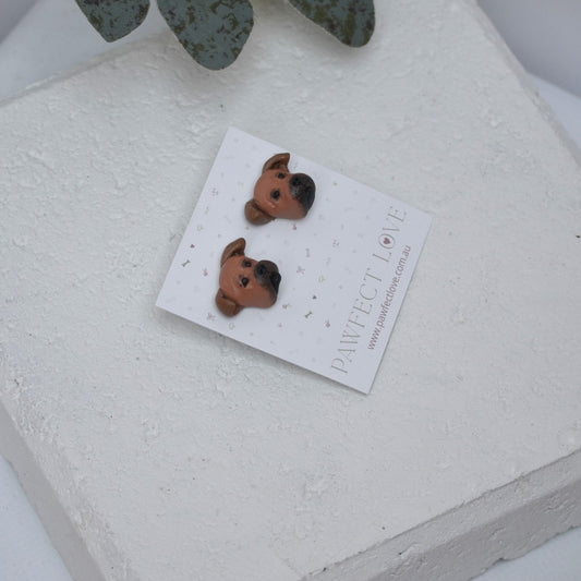 Handmade staffie stud earrings by Pawfect Love, positioned in front of white paver