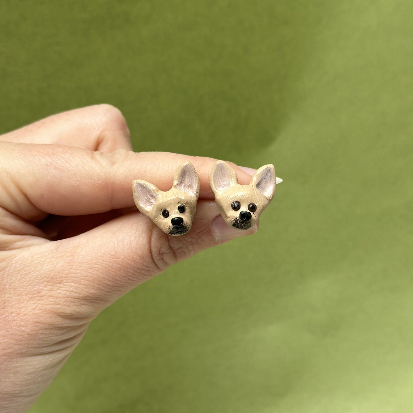 Handmade Chihuahua stud earrings by Pawfect Love, positioned in front of green background