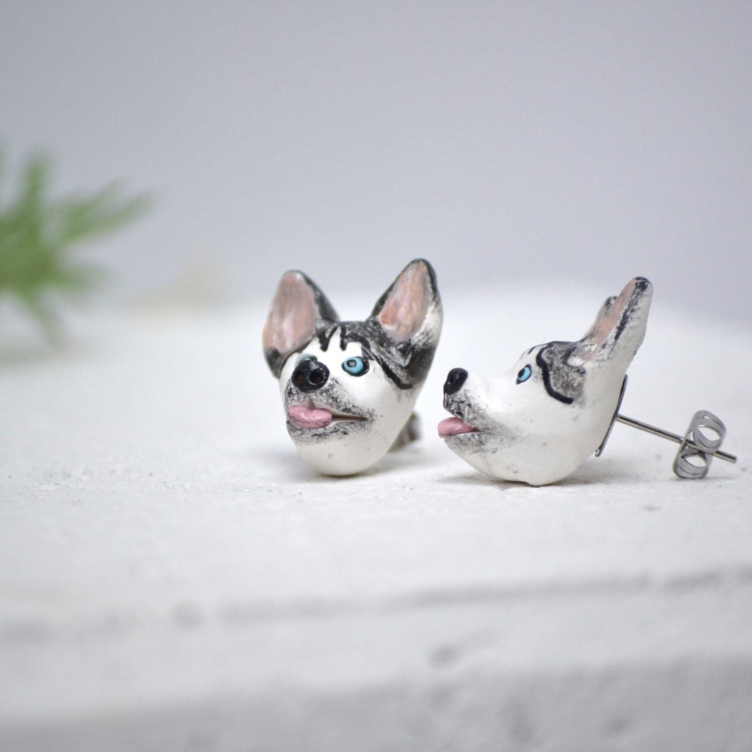 Handmade husky stud earrings by Pawfect Love, positioned on white paver