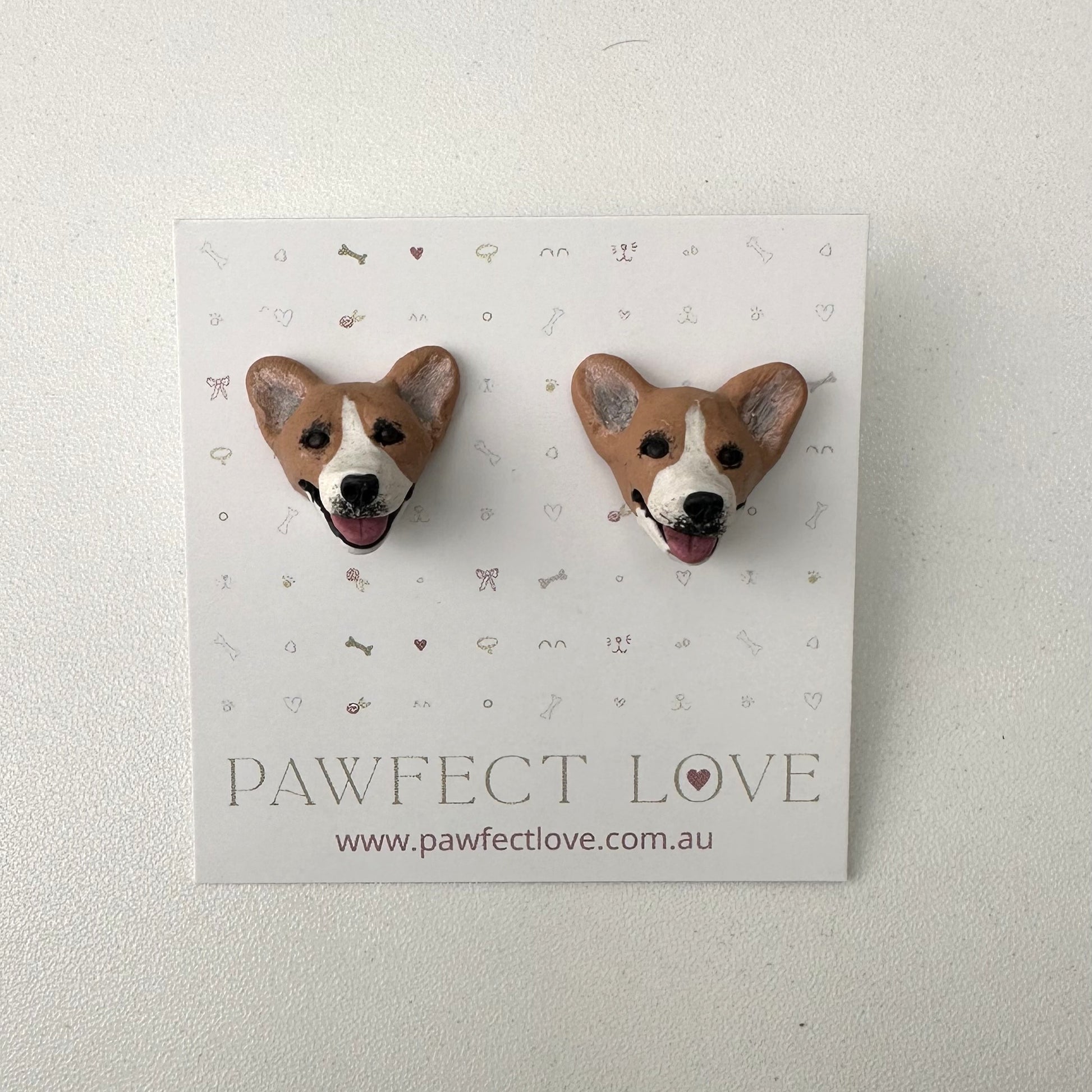 Pair of corgi dog-shaped earrings on a 'Pawfect Love' branded card.