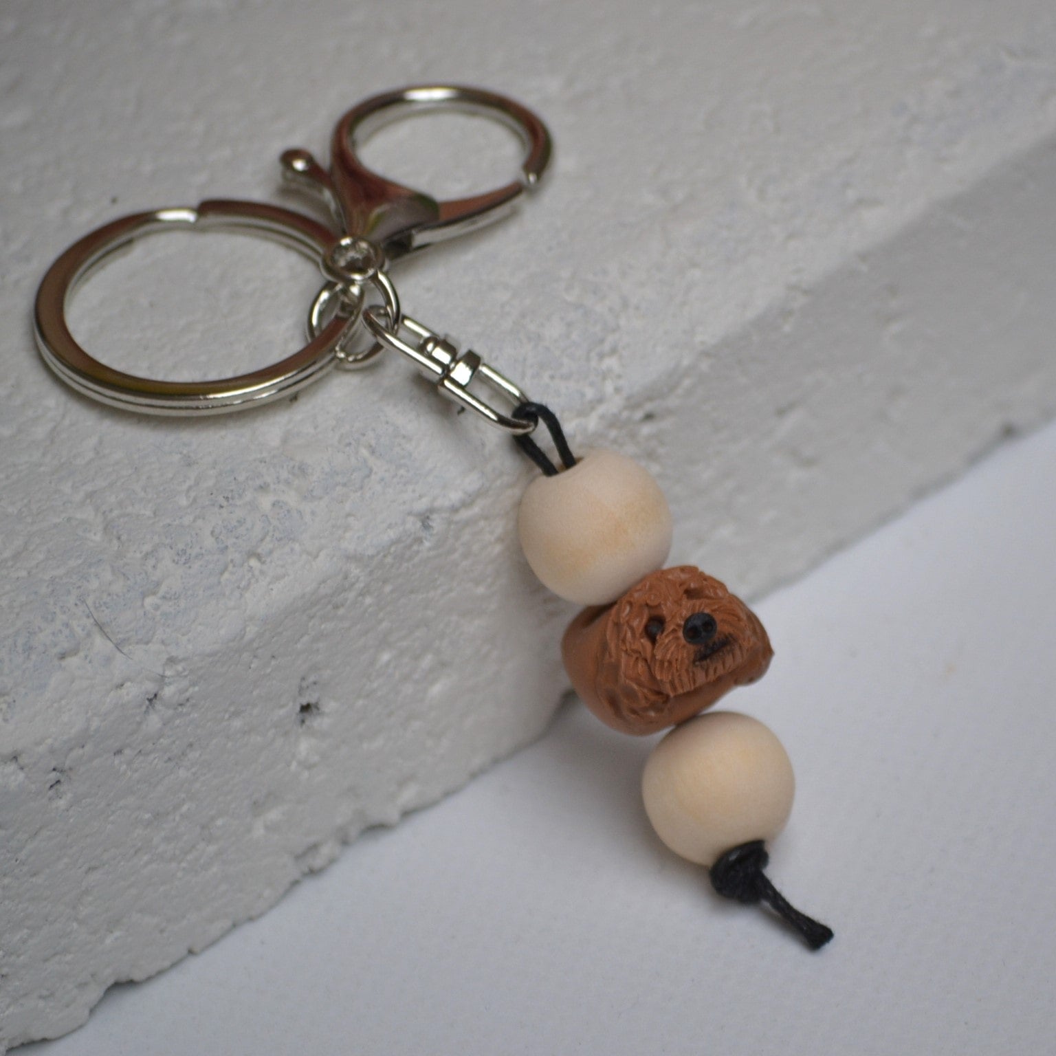 Handmade cavoodle polymer clay and timber keying on white textured background