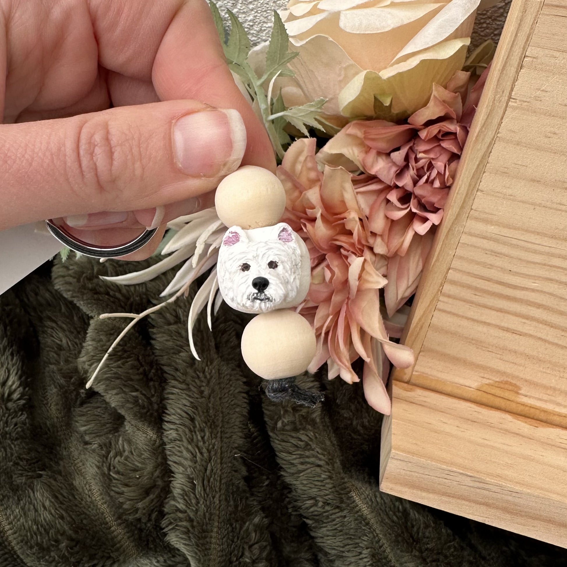 Small Westie handmade keyring with wooden balls on a floral background