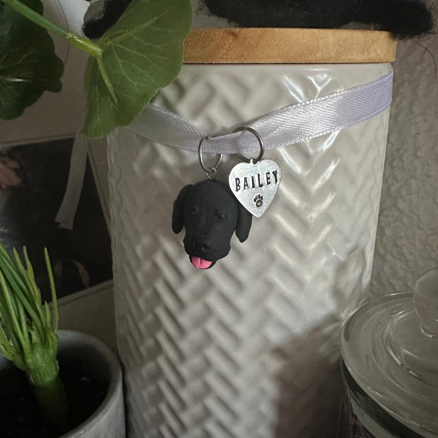 Custom dog urn charm hanging on urn with pet's ashes.