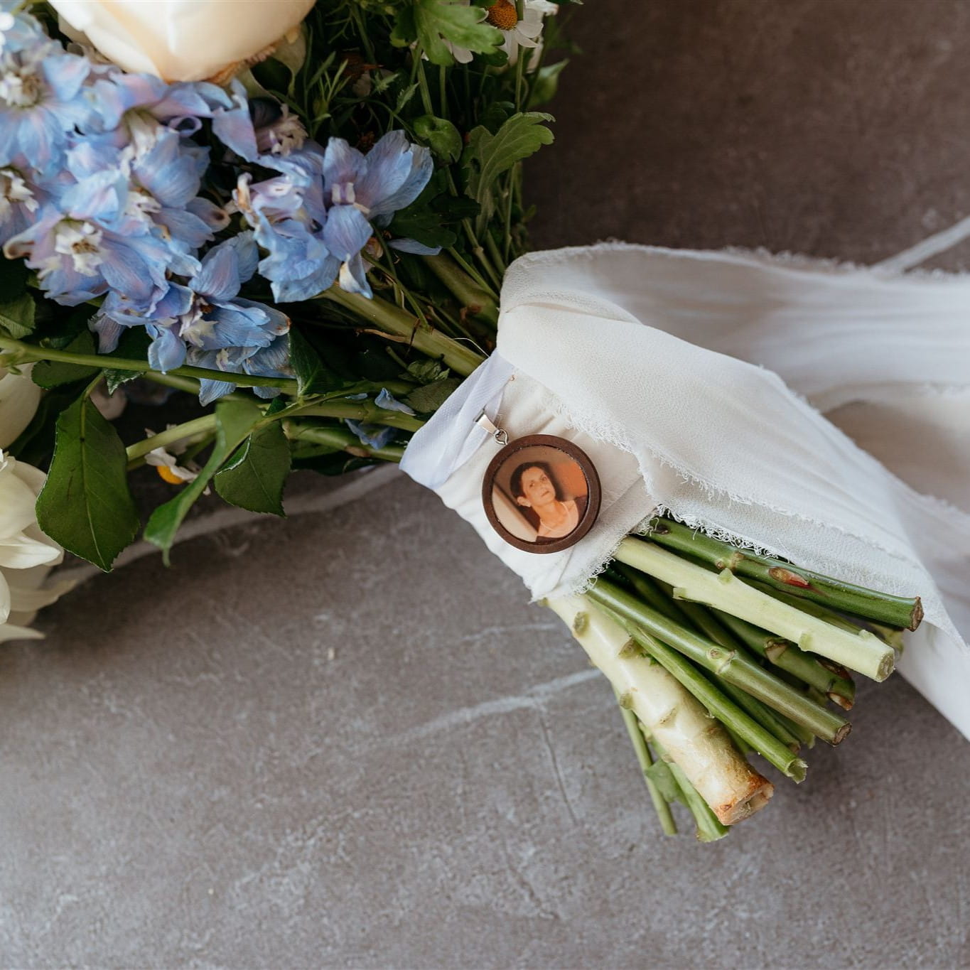 Bouquet of flowers with a photo charm on a neutral background