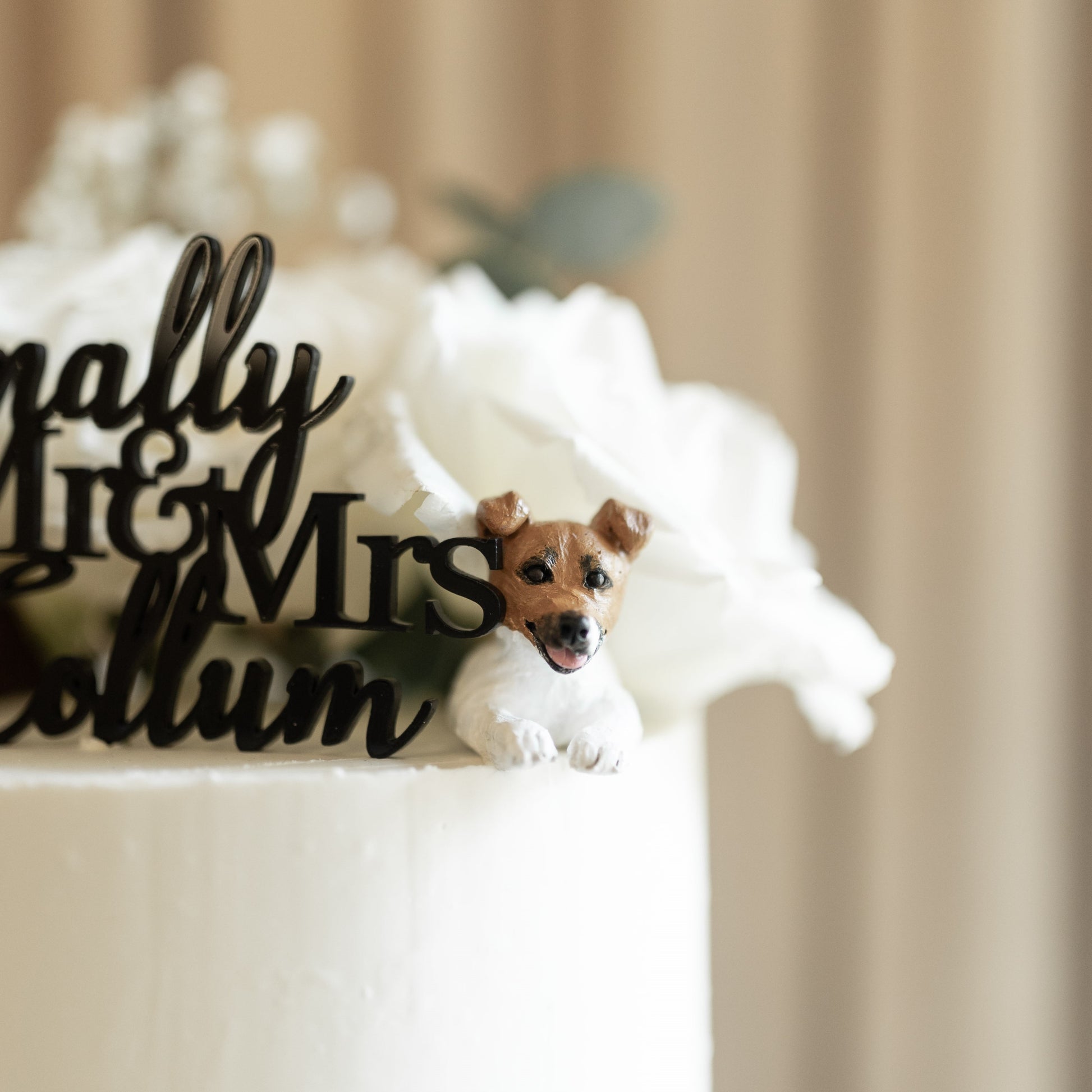 Custom Jack Russell dog peeking topper on a real wedding cake.
