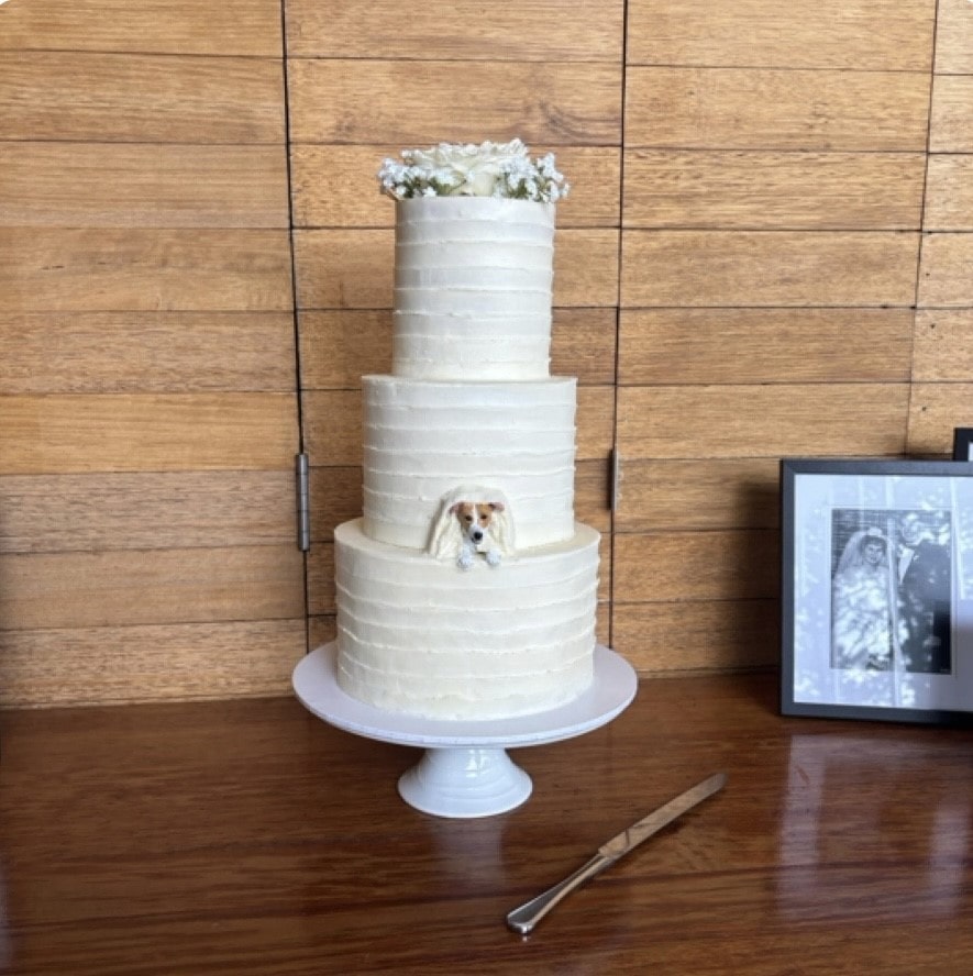 Custom Jack Russell dog peeking topper in a real wedding cake.