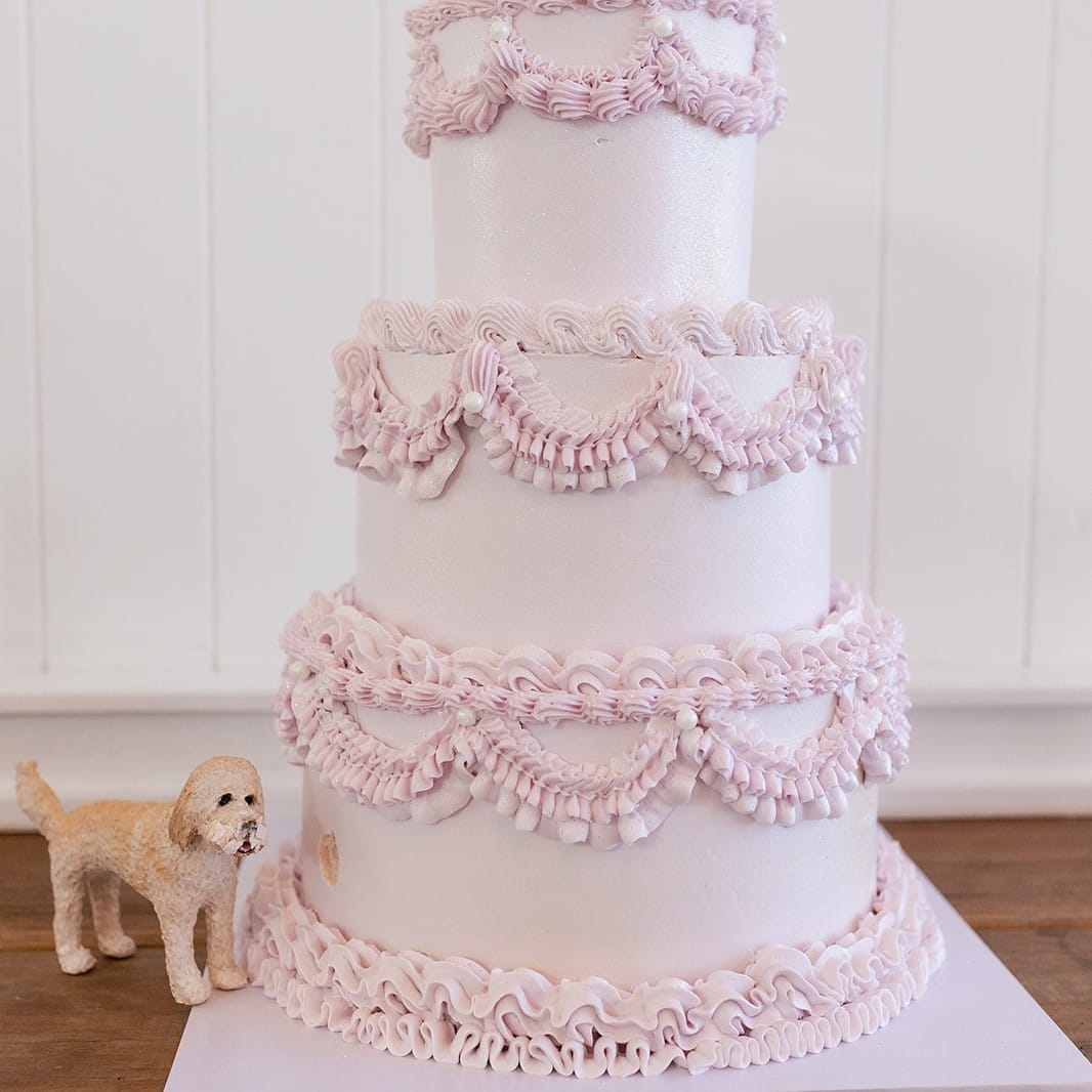 Custom dog cake topper beside Pink vintage lambeth 3 tier cake 