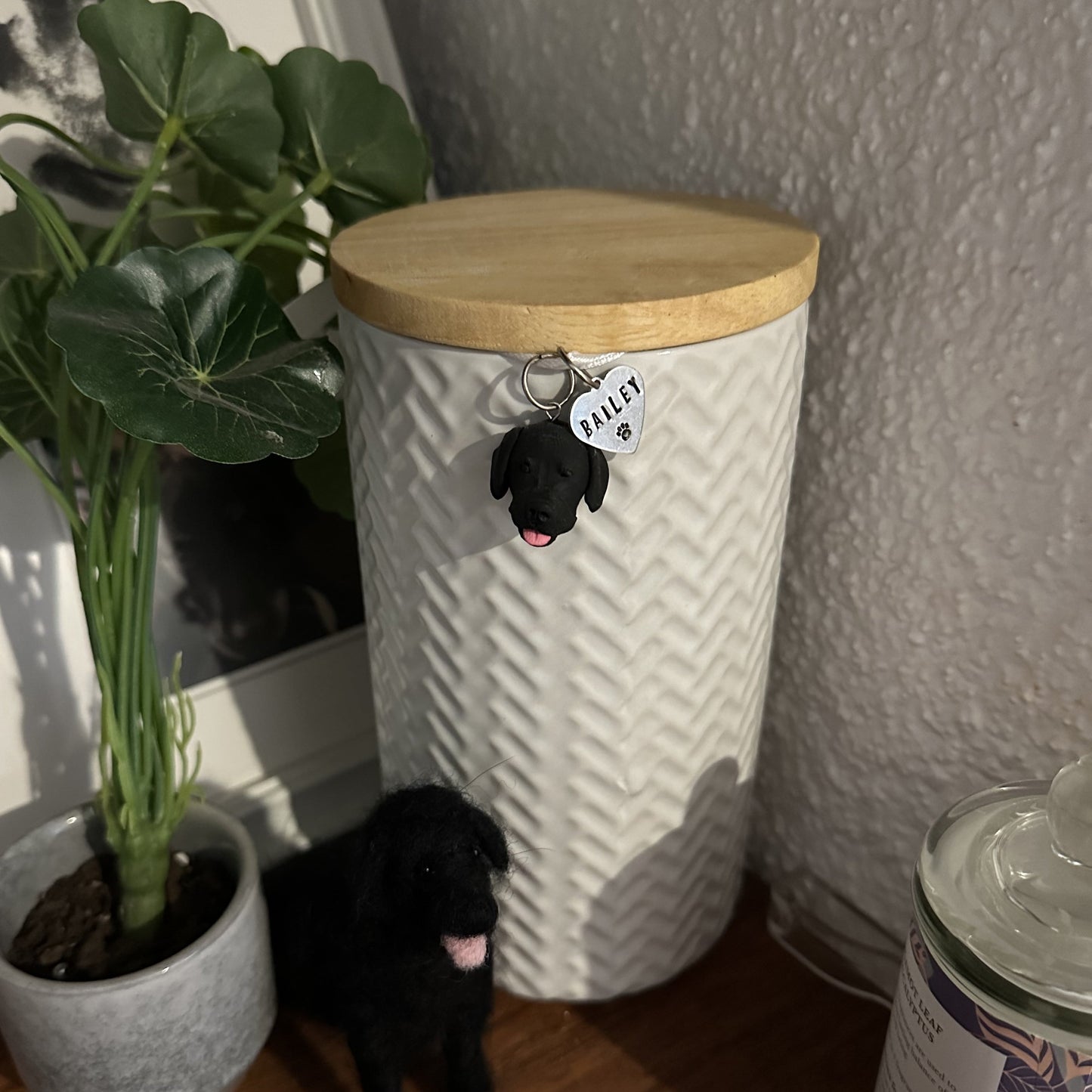 Custom dog urn charm hanging on urn with pet's ashes.